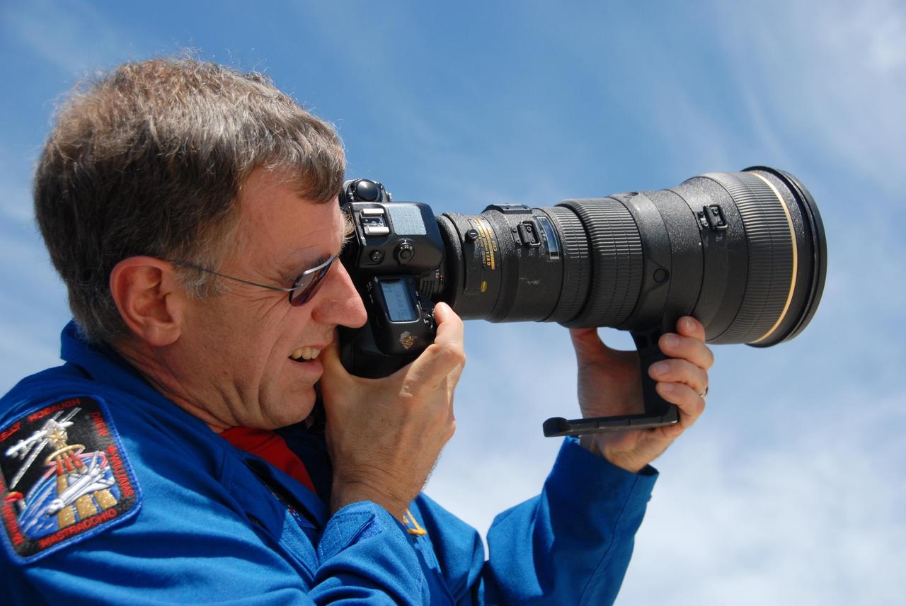 KENNEDY SPACE CENTER, Fla. -- Near Launch Pad 39A, STS-118 Mission Specialist Dave Williams practices using the camera and telephoto lens to photograph the external tank/solid rocket booster stack on Space Shuttle Endeavour. Williams and other mission specialists will take photos of the tank after separation from Endeavour after launch. The STS-118 crew is at Kennedy to take part in Terminal Countdown Demonstration Test activities, including M-113 training, payload familiarization, emergency egress training at the pad and a simulated launch countdown. The payload aboard Space Shuttle Endeavour includes the S5 truss, a SPACEHAB module and external stowage platform 3. The STS-118 mission is the 22nd flight to the International Space Station and is targeted for launch on Aug. 7. NASA/George Shelton
