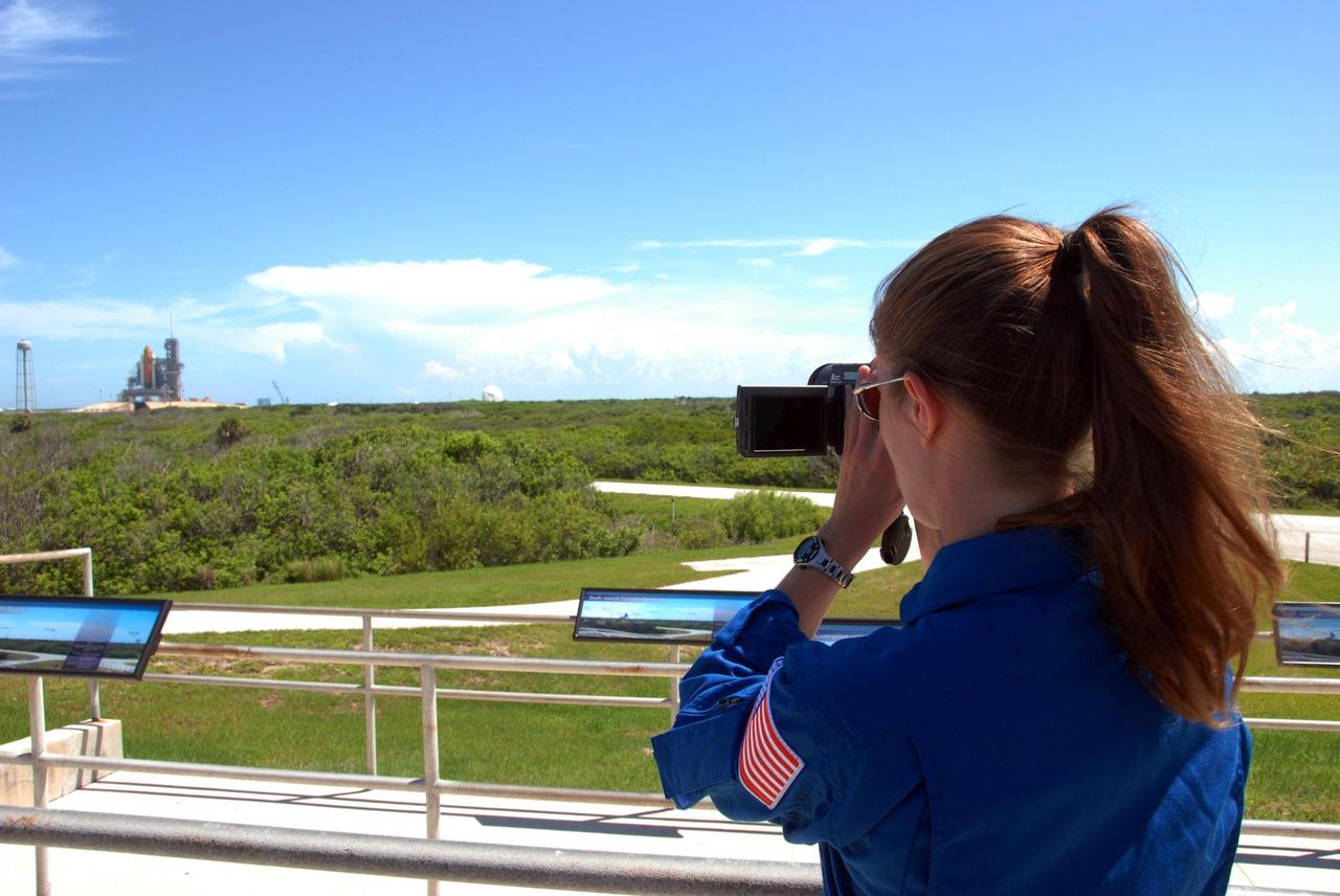 KENNEDY SPACE CENTER, Fla.  --   From the viewing site near Launch Pad 39A, STS-118 Mission Specialist Tracy Caldwell practices using a video camera to film the external tank/solid rocket booster stack on Space Shuttle Endeavour.  Caldwell will capture the  separation of the tank from Endeavour after launch. The STS-118 crew is at Kennedy to take part in Terminal Countdown Demonstration Test activities, including M-113 training, payload familiarization, emergency egress training at the pad and a simulated launch countdown. The payload aboard Space Shuttle Endeavour includes the S5 truss, a SPACEHAB module and external stowage platform 3. The STS-118 mission is the 22nd flight to the International Space Station and is targeted for launch on Aug. 7.  NASA/George Shelton