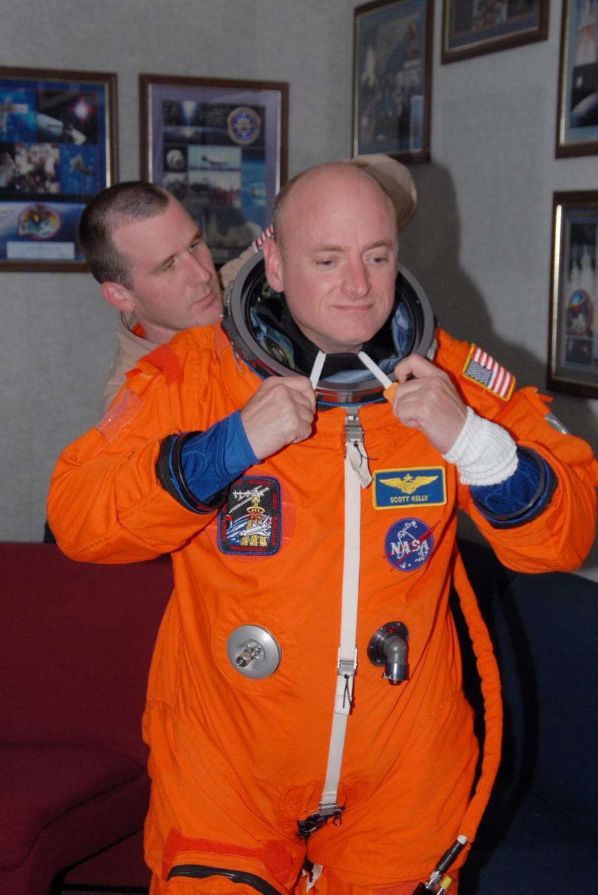 KENNEDY SPACE CENTER, Fla. -- STS-118 Commander Scott Kelly checks the fit of his launch and entry suit. The fitting is part of the Terminal Countdown Demonstration Test, or TCDT, activities that include a simulated launch countdown. Kelly is suiting up also for landing practice in the shuttle training aircraft, known as an STA. The STA is a Grumman American Aviation-built Gulf Stream II jet that was modified to simulate an orbiter's cockpit, motion and visual cues, and handling qualities. In flight, the STA duplicates the orbiter's atmospheric descent trajectory from approximately 35,000 feet altitude to landing on a runway. The STS-118 mission is the 22nd flight to the International Space Station and is targeted for launch on Aug. 7. The mission payload aboard Space Shuttle Endeavour includes the S5 truss, a SPACEHAB module and external stowage platform 3. NASA/George Shelton