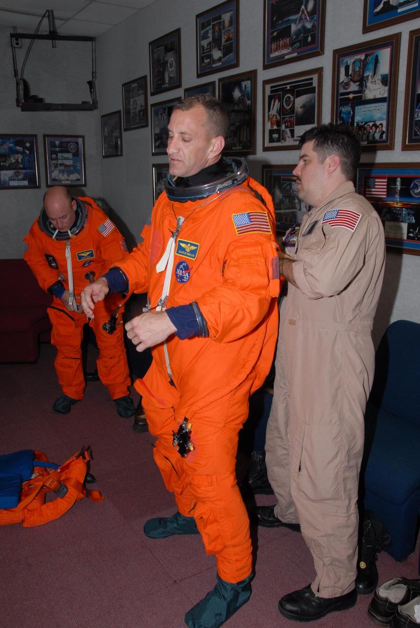KENNEDY SPACE CENTER, Fla.  --   STS-118 Commander Scott Kelly, left, and Pilot Charlie Hobaugh check the fit of their launch and entry suits.  The fitting is part of the Terminal Countdown Demonstration Test, or TCDT, activities that include a simulated launch countdown.   Kelly and Hobaugh are suiting up also for landing practice in the shuttle training aircraft, known as an STA.     The STA is a Grumman American Aviation-built Gulf Stream II jet that was modified to simulate an orbiter's cockpit, motion and visual cues, and handling qualities. In flight, the STA duplicates the orbiter's atmospheric descent trajectory from approximately 35,000 feet altitude to landing on a runway. The STS-118 mission is the 22nd flight to the International Space Station and is targeted for launch on Aug. 7.  The mission payload aboard Space Shuttle Endeavour includes the S5 truss, a SPACEHAB module and external stowage platform 3.  NASA/George Shelton