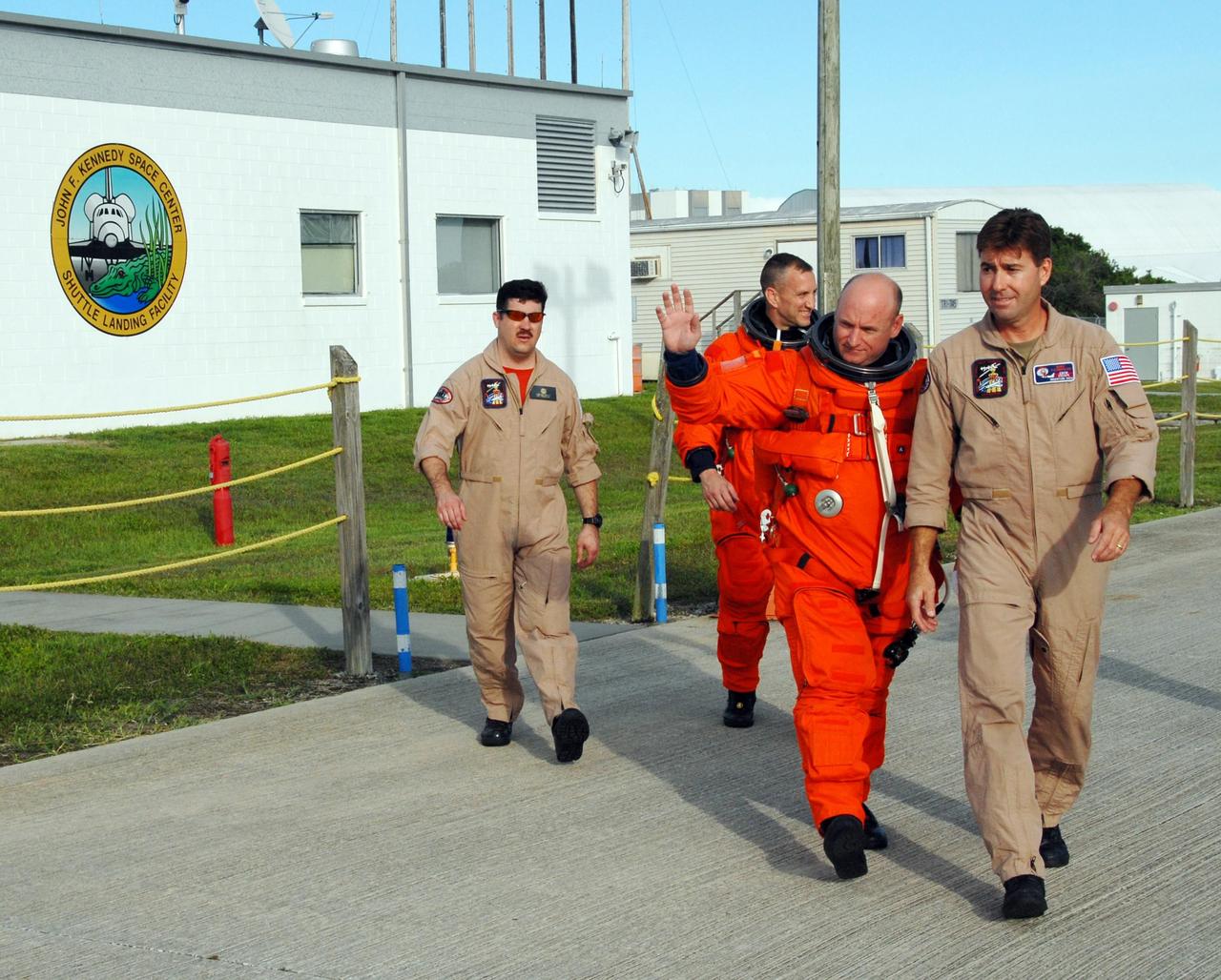 KENNEDY SPACE CENTER, Fla.  --   Dressed in their launch and entry suits, STS-118 Pilot Charlie Hobaugh and Commander Scott Kelly (waving) are headed for the runway for landing practice in the shuttle training aircraft, known as an STA.  The practice is part of Terminal Countdown Demonstration Test, or TCDT, activities that include a simulated launch countdown.  The STA is a Grumman American Aviation-built Gulf Stream II jet that was modified to simulate an orbiter's cockpit, motion and visual cues, and handling qualities. In flight, the STA duplicates the orbiter's atmospheric descent trajectory from approximately 35,000 feet altitude to landing on a runway. The STS-118 mission is the 22nd flight to the International Space Station and is targeted for launch on Aug. 7.  The mission payload aboard Space Shuttle Endeavour includes the S5 truss, a SPACEHAB module and external stowage platform 3.  NASA/George Shelton