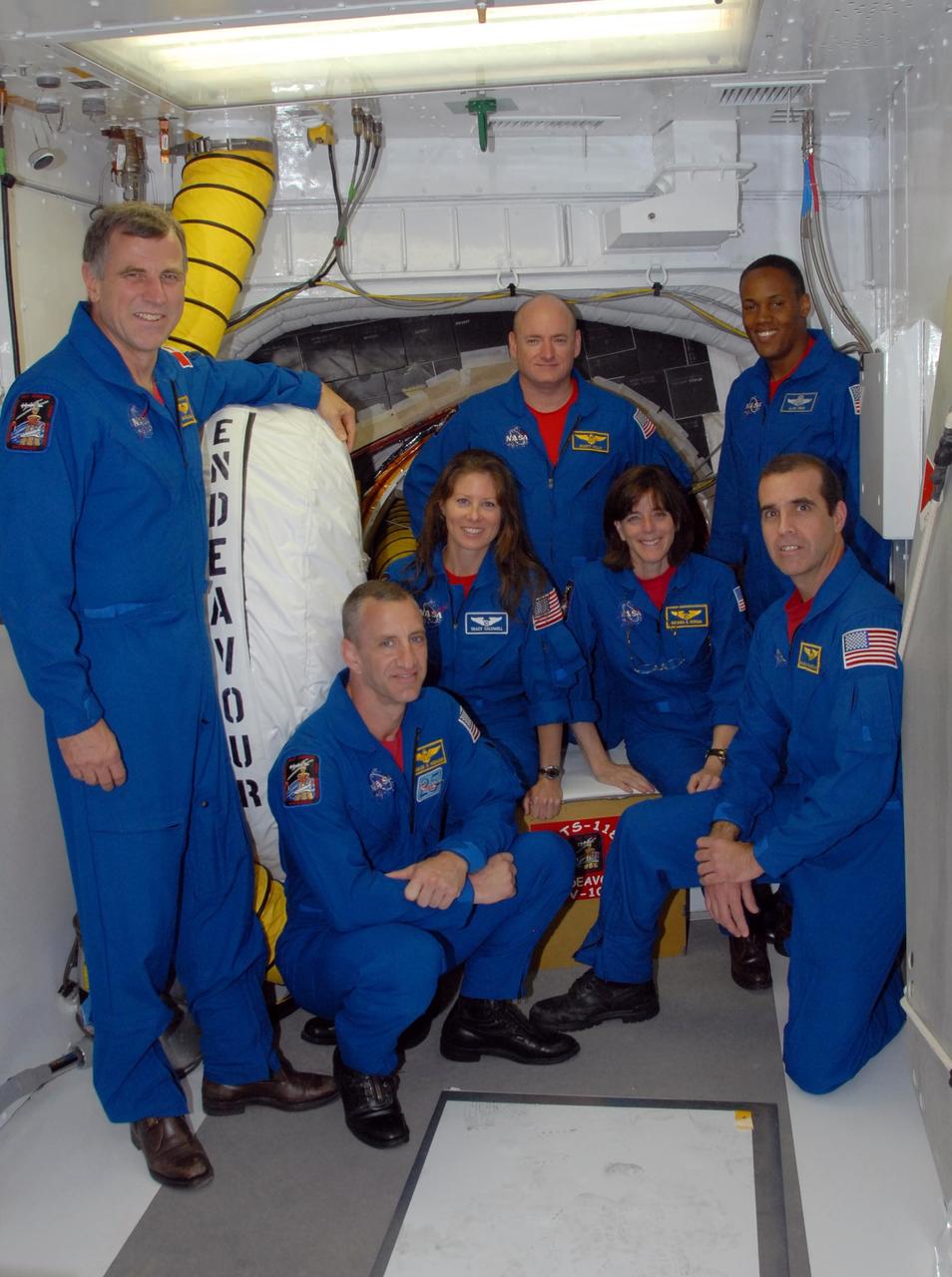 KENNEDY SPACE CENTER, Fla.  --  The STS-118 crew poses in front of the hatch opening on Space Shuttle Endeavour before the crew's morning training activities in the terminal countdown demonstration test, or TCDT.  Standing at left is Mission Specialist Dave Williams.  Standing in the back are Commander Scott Kelly (left) and Mission Specialist Alvin Drew; seated in the middle are Mission Specialists Tracy Caldwell (left) and Barbara R. Morgan; kneeling in front are Pilot Charlie Hobaugh (left) and Mission Specialist Rick Mastracchio.  Williams represents the Canadian Space Agency. Morgan joined NASA's Teacher in Space program in 1985 and was selected as an astronaut in 1998. TCDT activities include M-113 training, payload familiarization, the emergency egress training at the pad and a simulated launch countdown.  The mission is the 22nd flight to the International Space Station and Space Shuttle Endeavour will carry a payload including the S5 truss, a SPACEHAB module and external stowage platform 3. STS-118 is targeted for launch on Aug. 7.  NASA/George Shelton