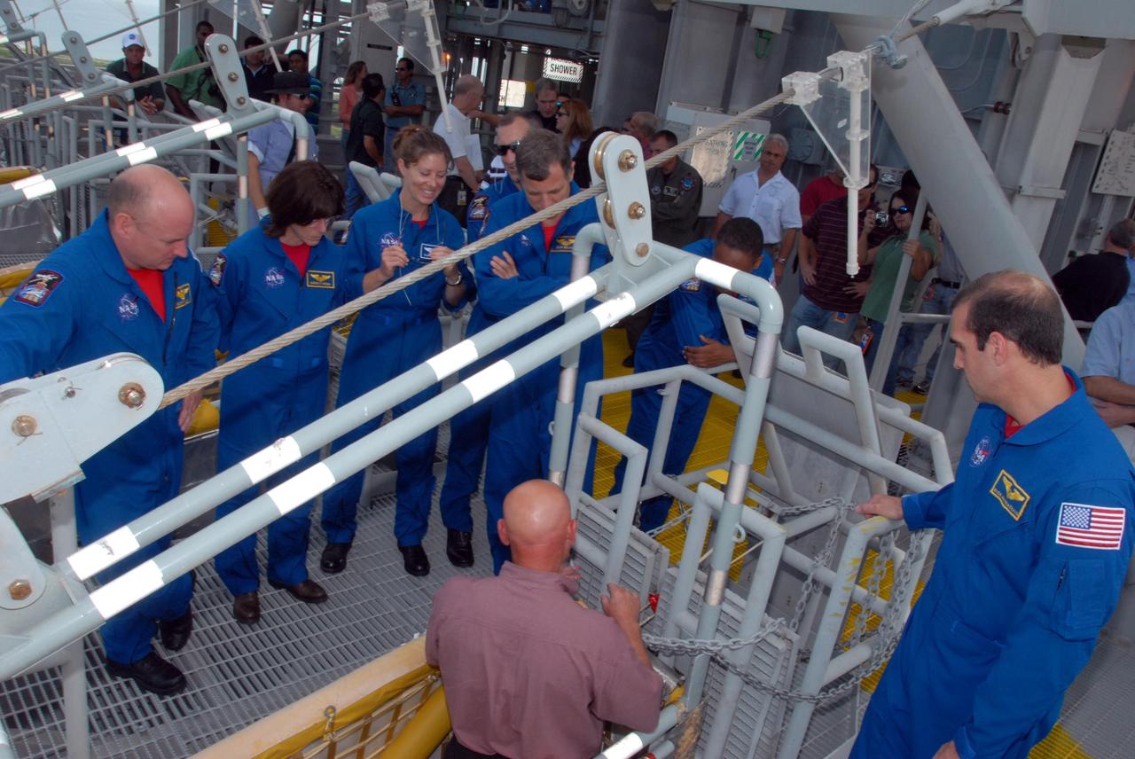 KENNEDY SPACE CENTER, Fla.  --   On an upper level of the Pad 39A fixed service structure, the STS-118 crew members look at the slidewire basket that is part of the emergency egress system.  On the left are Commander Scott Kelly and Mission Specialists Barbara R. Morgan, Tracy Caldwell, Dave Williams and Alvin Drew.  On the right is Mission Specialist Rick Mastracchio.  Morgan joined NASA's Teacher in Space program in 1985 and was selected as an astronaut in 1998. Williams represents the Canadian Space Agency. The crew is at Kennedy for training activities in the terminal countdown demonstration test, or TCDT. TCDT activities include M-113 training, payload familiarization, the emergency egress training at the pad and a simulated launch countdown.  The mission is the 22nd flight to the International Space Station and Space Shuttle Endeavour will carry a payload including the S5 truss, a SPACEHAB module and external stowage platform 3. STS-118 is targeted for launch on Aug. 7.  NASA/George Shelton