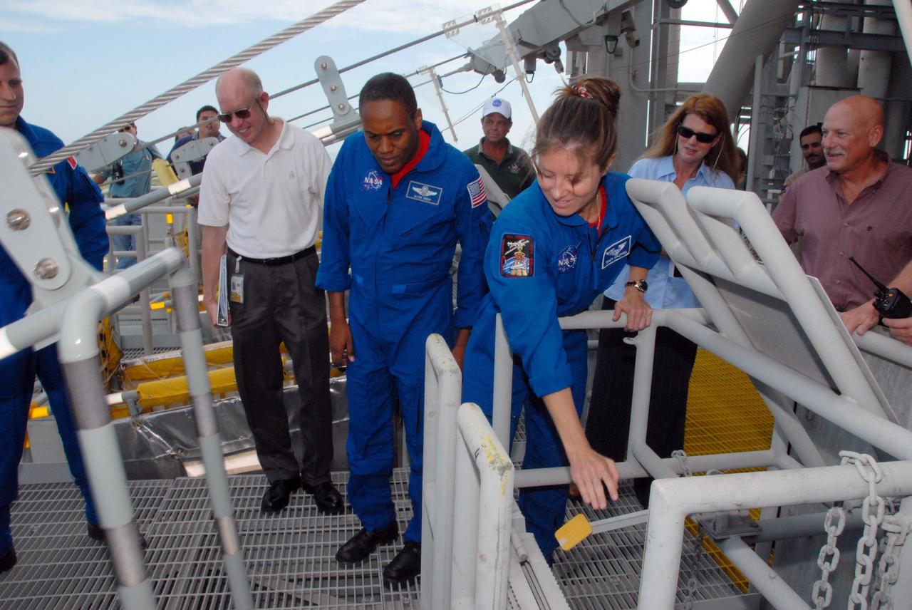 KENNEDY SPACE CENTER, Fla.  --  On an upper level of the Pad 39A fixed service structure, the STS-118 crew members get directions about using the slidewire basket that is part of the emergency egress system.  At right, Mission Specialist Tracy Caldwell identifies the pull lever to release the basket.  At far left is Mission Specialist Dave Williams, who represents the Canadian Space Agency.  At center is Mission Specialist Alvin Drew. The crew is at Kennedy for terminal countdown demonstration test, or TCDT, training activities. Those activities include M-113 training, payload familiarization, the emergency egress training at the pad and a simulated launch countdown.  The mission is the 22nd flight to the International Space Station and Space Shuttle Endeavour will carry a payload including the S5 truss, a SPACEHAB module and external stowage platform 3. STS-118 is targeted for launch on Aug. 7.  NASA/George Shelton