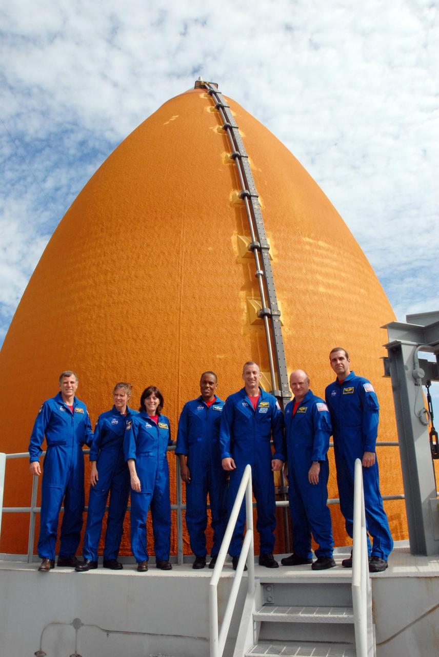 KENNEDY SPACE CENTER, Fla.  --  On the top level of the Pad 39A fixed service structure, the STS-118 crew takes a break from training activities in the terminal countdown demonstration test, or TCDT.  From left are Mission Specialists Dave Williams, Tracy Caldwell, Barbara R. Morgan and Alvin Drew, Pilot Charlie Hobaugh, Commander Scott Kelly and Mission Specialist Rick Mastracchio. Williams represents the Canadian Space Agency. Morgan joined NASA's Teacher in Space program in 1985 and was selected as an astronaut in 1998. Behind them is the top of the external tank.  TCDTactivities include M-113 training, payload familiarization, the emergency egress training at the pad and a simulated launch countdown.  The mission is the 22nd flight to the International Space Station and Space Shuttle Endeavour will carry a payload including the S5 truss, a SPACEHAB module and external stowage platform 3. STS-118 is targeted for launch on Aug. 7.  NASA/George Shelton