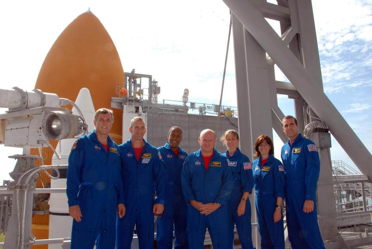 KENNEDY SPACE CENTER, Fla.  --   On the top level of the Pad 39A fixed service structure, the STS-118 crew takes a break from training activities in the terminal countdown demonstration test, or TCDT.  From left are Mission Specialist Dave Williams, Pilot Charlie Hobaugh, Mission Specialist Alvin Drew, Commander Scott Kelly and Mission Specialists Tracy Caldwell, Barbara R. Morgan and Rick Mastracchio.  Williams represents the Canadian Space Agency. Morgan joined NASA's Teacher in Space program in 1985 and was selected as an astronaut in 1998.  Behind them is the top of the external tank and a solid rocket booster. TCDTactivities include M-113 training, payload familiarization, the emergency egress training at the pad and a simulated launch countdown.  The mission is the 22nd flight to the International Space Station and Space Shuttle Endeavour will carry a payload including the S5 truss, a SPACEHAB module and external stowage platform 3. STS-118 is targeted for launch on Aug. 7.  NASA/George Shelton