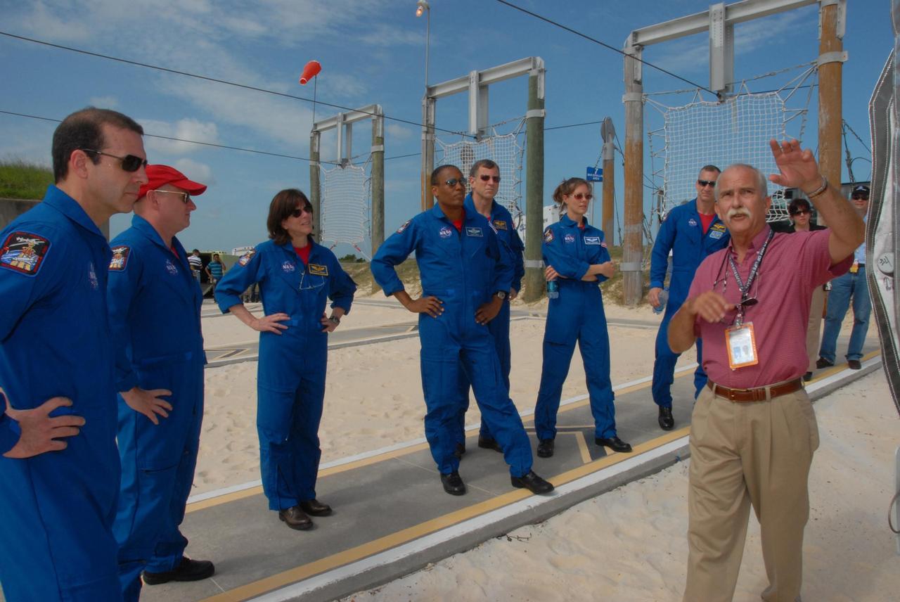 KENNEDY SPACE CENTER, Fla.  --   Back on the slidewire landing area of Pad 39A, the STS-118 crew learns about landing in the baskets in the event of an emergency. From left are Mission Specialist Rick Mastracchio, Commander Scott Kelly, Mission Specialists Barbara R. Morgan, Alvin Drew, Dave Williams and Tracy Caldwell, and Pilot Charlie Hobaugh. Morgan joined NASA's Teacher in Space program in 1985 and was selected as an astronaut in 1998.  Williams represents the Canadian Space Agency. The crew is at Kennedy for training activities in the terminal countdown demonstration test, or TCDT. TCDTactivities include M-113 training, payload familiarization, the emergency egress training at the pad and a simulated launch countdown.  The mission is the 22nd flight to the International Space Station and Space Shuttle Endeavour will carry a payload including the S5 truss, a SPACEHAB module and external stowage platform 3. STS-118 is targeted for launch on Aug. 7.  NASA/George Shelton