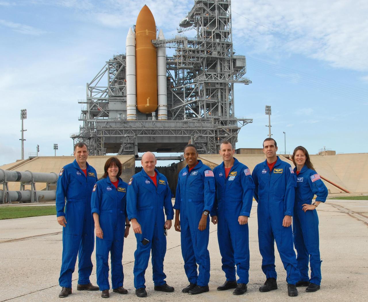 KENNEDY SPACE CENTER, Fla.  --  The STS-118 crew poses for a photo on Launch Pad 39A during training activities in the terminal countdown demonstration test, or TCDT. From left are Mission Specialists Dave Williams and Barbara R. Morgan, Commander Scott Kelly, Mission Specialist Alvin Drew, Pilot Charlie Hobaugh, and Mission Specialists Rick Mastracchio and Tracy Caldwell.  Williams represents the Canadian Space Agency.  Morgan joined NASA's Teacher in Space program in 1985 and was selected as an astronaut in 1998.  Behind them can be seen the solid rocket boosters and external tank of Space Shuttle Endeavour atop the mobile launcher platform. TCDT activities include M-113 training, payload familiarization, the emergency egress training at the pad and a simulated launch countdown.  The mission is the 22nd flight to the International Space Station and Space Shuttle Endeavour will carry a payload including the S5 truss, a SPACEHAB module and external stowage platform 3. STS-118 is targeted for launch on Aug. 7.  Photo credit: NASA/George Shelton