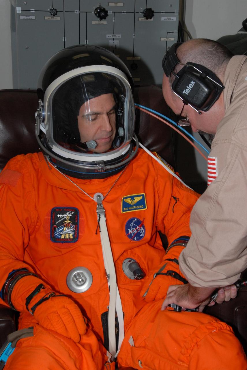 KENNEDY SPACE CENTER, Fla. -- STS-118 Mission Specialist Rick Mastracchio gets help suiting up before the simulated launch countdown that concludes the terminal countdown demonstration test, or TCDT. The STS-118 crew has been at Kennedy for the TCDT activities that also include M-113 training, payload familiarization and emergency egress training at the pad. The mission is the 22nd flight to the International Space Station and Space Shuttle Endeavour will carry a payload including the S5 truss, a SPACEHAB module and external stowage platform 3. STS-118 is targeted for launch on Aug. 7. Photo credit: NASA/George Shelton