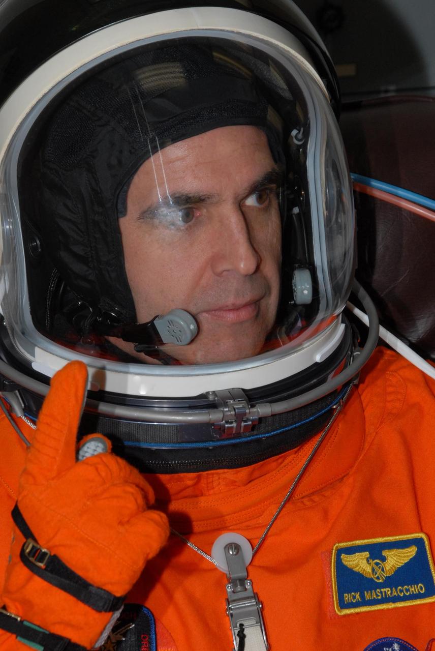 KENNEDY SPACE CENTER, Fla.  --  STS-118 Mission Specialist Rick Mastracchio adjusts his helmet during suitup before the simulated launch countdown that concludes the terminal countdown demonstration test, or TCDT. The STS-118 crew has been at Kennedy for the TCDT activities that also include M-113 training, payload familiarization and emergency egress training at the pad.  The mission is the 22nd flight to the International Space Station and Space Shuttle Endeavour will carry a payload including the S5 truss, a SPACEHAB module and external stowage platform 3. STS-118 is targeted for launch on Aug. 7.  Photo credit: NASA/George Shelton