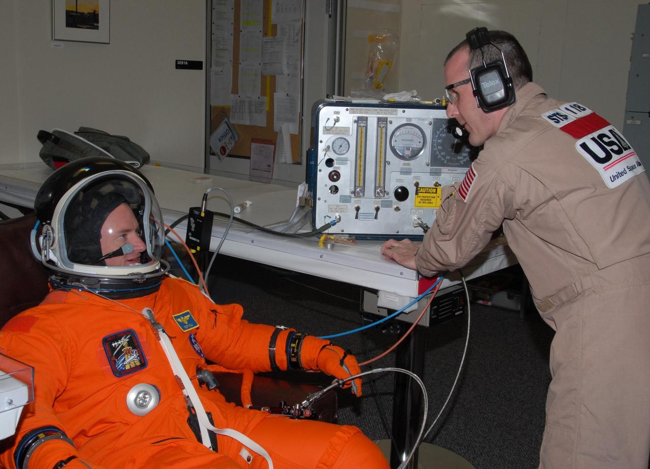 KENNEDY SPACE CENTER, Fla.  --  STS-118 Commander Scott Kelly's launch and entry suit is monitored after his suitup for the simulated launch countdown that concludes the terminal countdown demonstration test, or TCDT. The STS-118 crew has been at Kennedy for the TCDT activities that also include M-113 training, payload familiarization and emergency egress training at the pad.  The mission is the 22nd flight to the International Space Station and Space Shuttle Endeavour will carry a payload including the S5 truss, a SPACEHAB module and external stowage platform 3. STS-118 is targeted for launch on Aug. 7.  Photo credit: NASA/George Shelton
