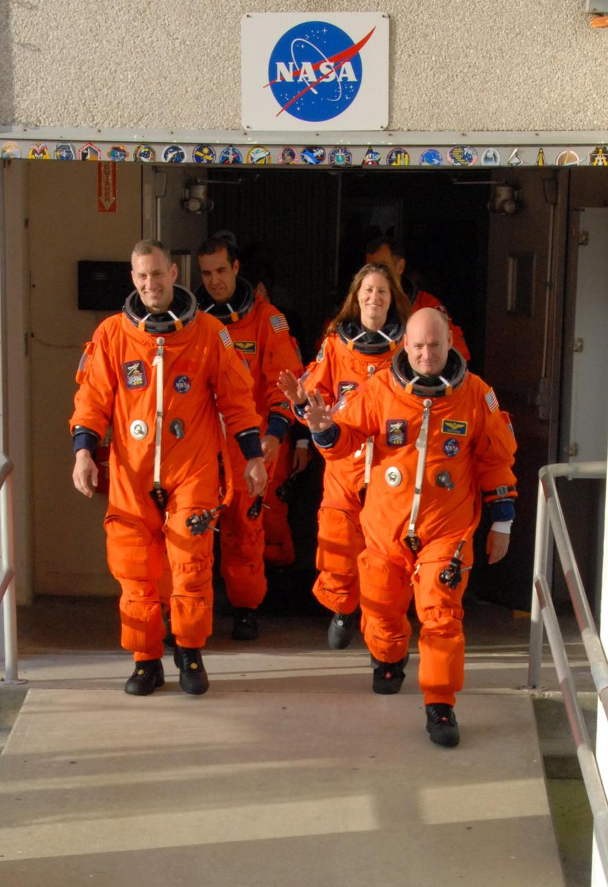 KENNEDY SPACE CENTER, Fla.  --  The STS-118 crew walks out of the Operations and Checkout Building, heading for Launch Pad 39A and a simulated launch countdown.  On the left, Pilot Charlie Hobaugh leads one column, with Mission Specialist Rick Mastracchio behind him.  On the right, Commander Scott Kelly leads, with Mission Specialists Tracy Caldwell and Dave Williams behind.  Not pictured are Mission Specialists Alvin Drew and teacher-turned-astronaut Barbara R. Morgan. The countdown concludes the terminal countdown demonstration test, or TCDT.  The STS-118 crew has been at Kennedy for the TCDT activities that also include M-113 training, payload familiarization and emergency egress training at the pad.  The mission is the 22nd flight to the International Space Station and Space Shuttle Endeavour will carry a payload including the S5 truss, a SPACEHAB module and external stowage platform 3. STS-118 is targeted for launch on Aug. 7.  Photo credit: NASA/George Shelton