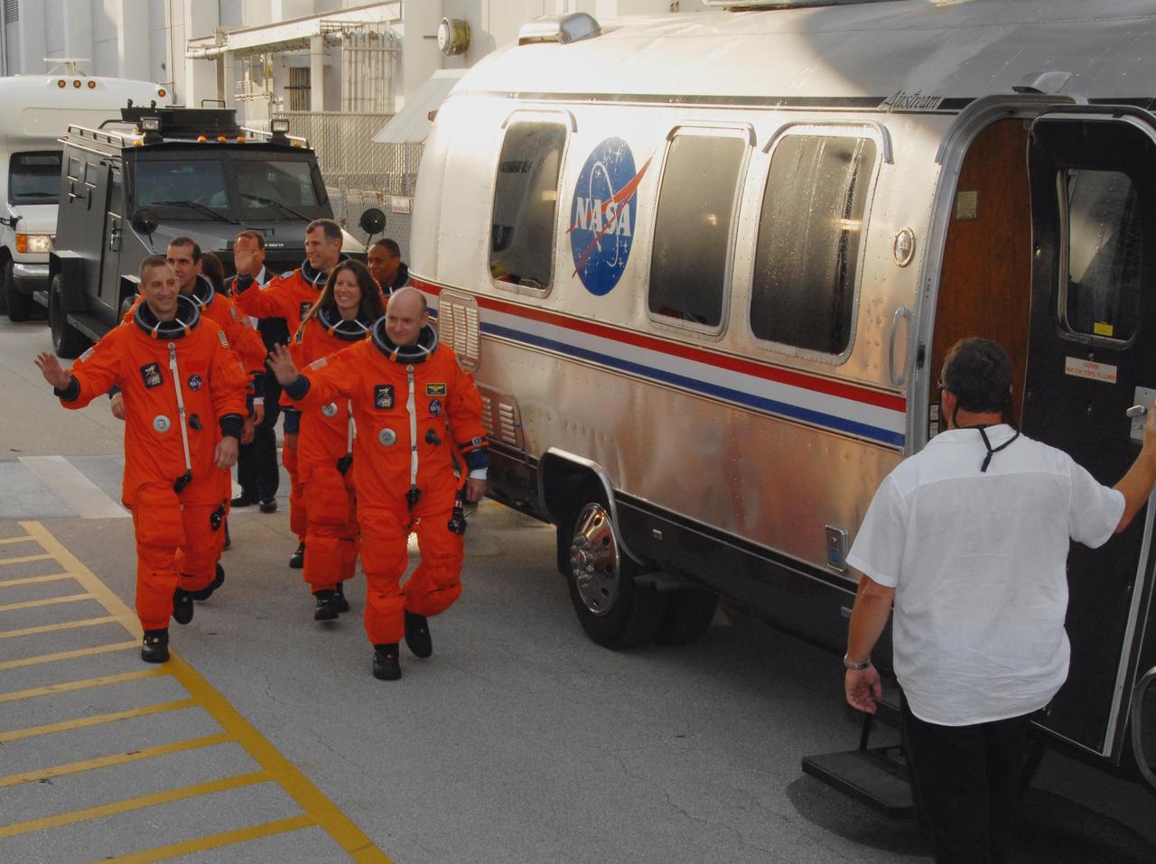 KENNEDY SPACE CENTER, Fla.  --  The STS-118 crew walks toward the Astrovan that will take them to Launch Pad 39A for a simulated launch countdown.  On the left are Pilot Charlie Hobaugh leading the way and Mission Specialist Rick Mastracchio.  ON the right, Commander Scott Kelly leads with (front to back) Mission Specialists Tracy Caldwell, Dave Williams and Alvin Drew.  Not visible is teacher-turned-astronaut Barbara R. Morgan, also a mission specialist.  The countdown concludes the terminal countdown demonstration test, or TCDT.  The STS-118 crew has been at Kennedy for the TCDT activities that also include M-113 training, payload familiarization and emergency egress training at the pad.  The mission is the 22nd flight to the International Space Station and Space Shuttle Endeavour will carry a payload including the S5 truss, a SPACEHAB module and external stowage platform 3. STS-118 is targeted for launch on Aug. 7.  Photo credit: NASA/George Shelton