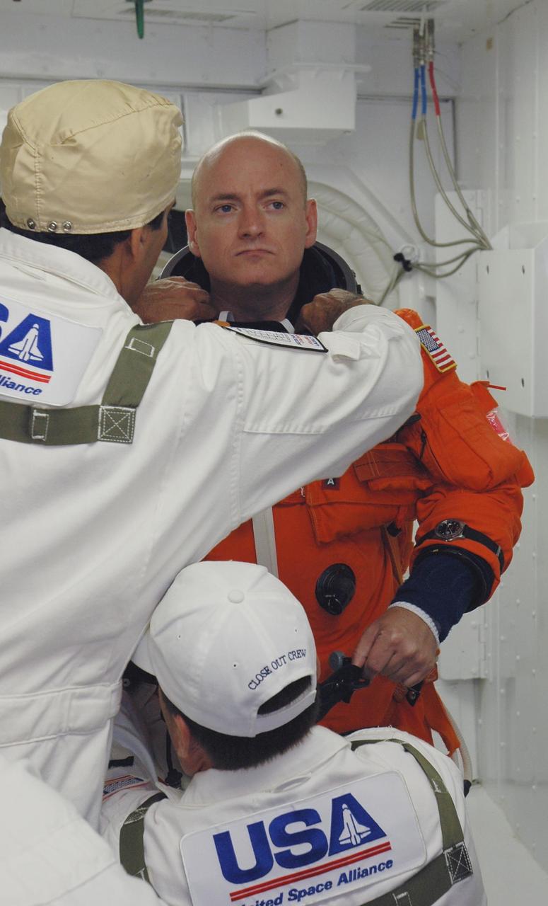 KENNEDY SPACE CENTER, Fla. -- In the White Room on Launch Pad 39A, the closeout crew prepares STS-118 Commander Scott Kelly's launch and entry suit before he enters Space Shuttle Endeavour. Kelly and the rest of the crew are taking part in a simulated launch countdown, the culmination of terminal countdown demonstration test activities. The White Room is situated at the end of the orbiter access arm and provides entry into the orbiter. TCDT activities also include M-113 training, payload familiarization and emergency egress training at the pad. The mission is the 22nd flight to the International Space Station and Space Shuttle Endeavour will carry a payload including the S5 truss, a SPACEHAB module and external stowage platform 3. STS-118 is targeted for launch on Aug. 7. Photo credit: NASA/Amanda Diller
