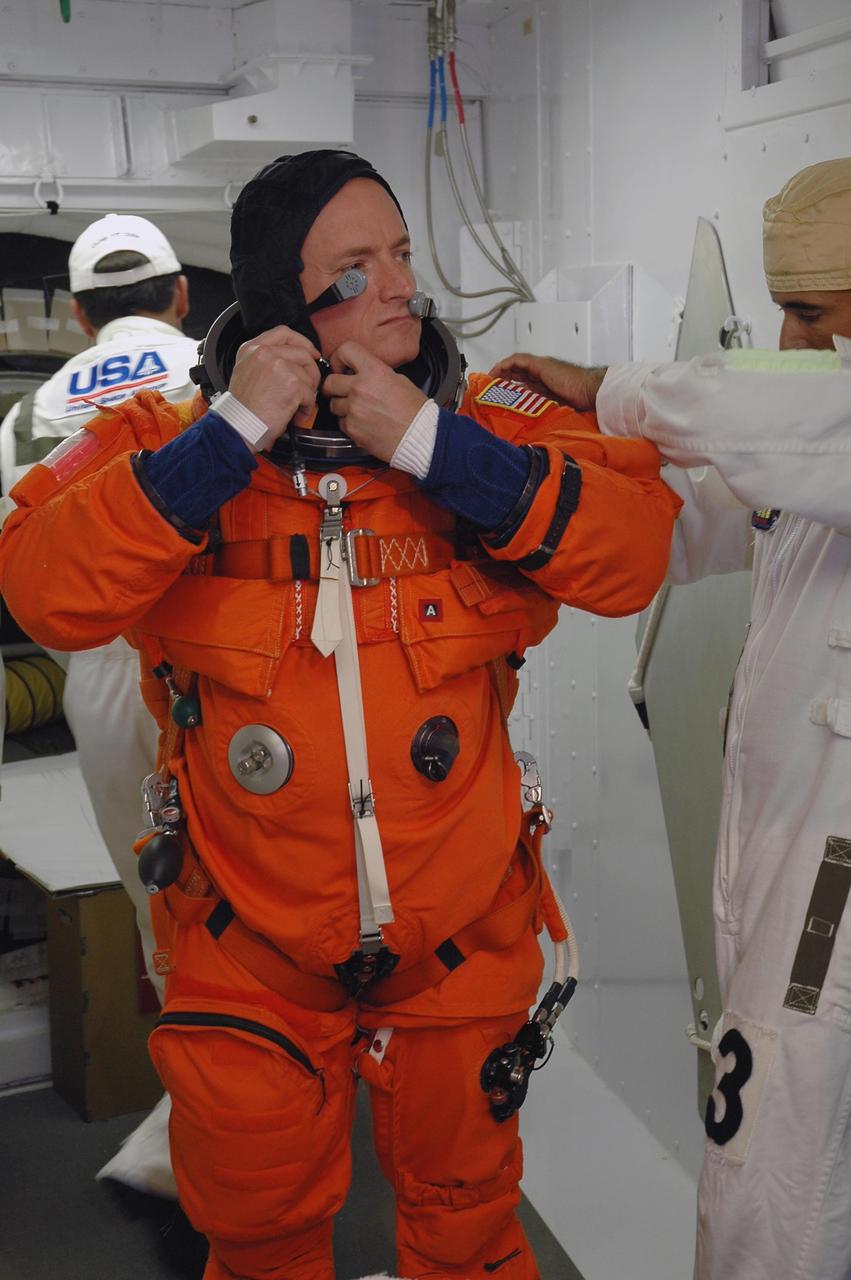 KENNEDY SPACE CENTER, Fla. -- In the White Room on Launch Pad 39A, STS-118 Commander Scott Kelly adjusts his launch and entry suit before he enters Space Shuttle Endeavour. Kelly and the rest of the crew are taking part in a simulated launch countdown, the culmination of terminal countdown demonstration test activities. The White Room is situated at the end of the orbiter access arm and provides entry into the orbiter. TCDT activities also include M-113 training, payload familiarization and emergency egress training at the pad. The mission is the 22nd flight to the International Space Station and Space Shuttle Endeavour will carry a payload including the S5 truss, a SPACEHAB module and external stowage platform 3. STS-118 is targeted for launch on Aug. 7. Photo credit: NASA/Amanda Diller