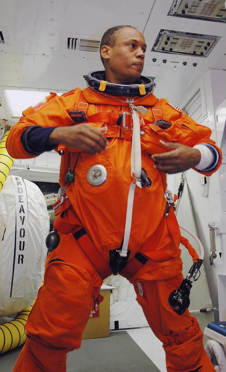 KENNEDY SPACE CENTER, Fla. -- In the White Room on Launch Pad 39A, STS-118 Mission Specialist Alvin Drew adjusts his launch and entry suit before he enters Space Shuttle Endeavour. Drew and the rest of the crew are taking part in a simulated launch countdown, the culmination of terminal countdown demonstration test activities. The White Room is situated at the end of the orbiter access arm and provides entry into the orbiter. TCDT activities also include M-113 training, payload familiarization and emergency egress training at the pad. The mission is the 22nd flight to the International Space Station and Space Shuttle Endeavour will carry a payload including the S5 truss, a SPACEHAB module and external stowage platform 3. STS-118 is targeted for launch on Aug. 7. Photo credit: NASA/Amanda Diller
