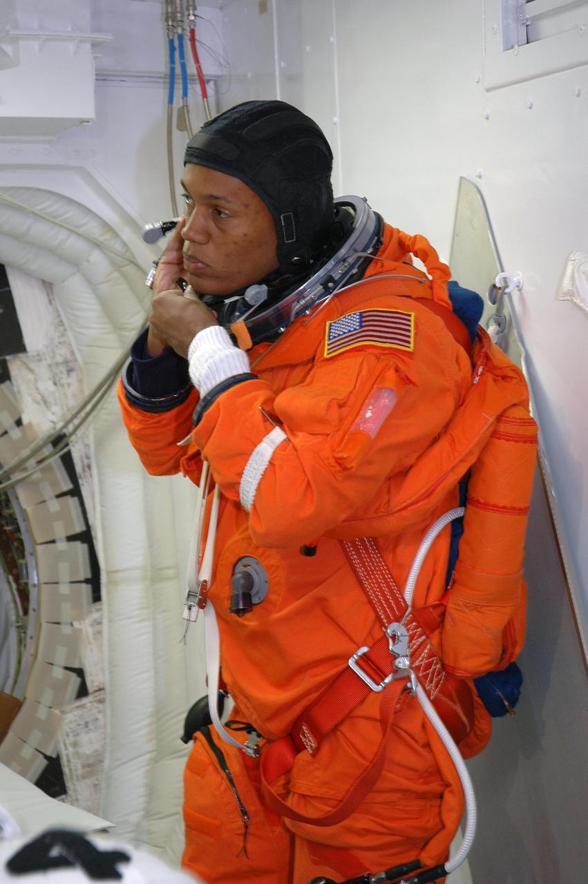 KENNEDY SPACE CENTER, Fla. -- In the White Room on Launch Pad 39A, STS-118 Mission Specialist Alvin Drew adjusts his launch and entry suit before he enters Space Shuttle Endeavour. Drew and the rest of the crew are taking part in a simulated launch countdown, the culmination of terminal countdown demonstration test activities. The White Room is situated at the end of the orbiter access arm and provides entry into the orbiter. TCDT activities also include M-113 training, payload familiarization and emergency egress training at the pad. The mission is the 22nd flight to the International Space Station and Space Shuttle Endeavour will carry a payload including the S5 truss, a SPACEHAB module and external stowage platform 3. STS-118 is targeted for launch on Aug. 7. Photo credit: NASA/Amanda Diller