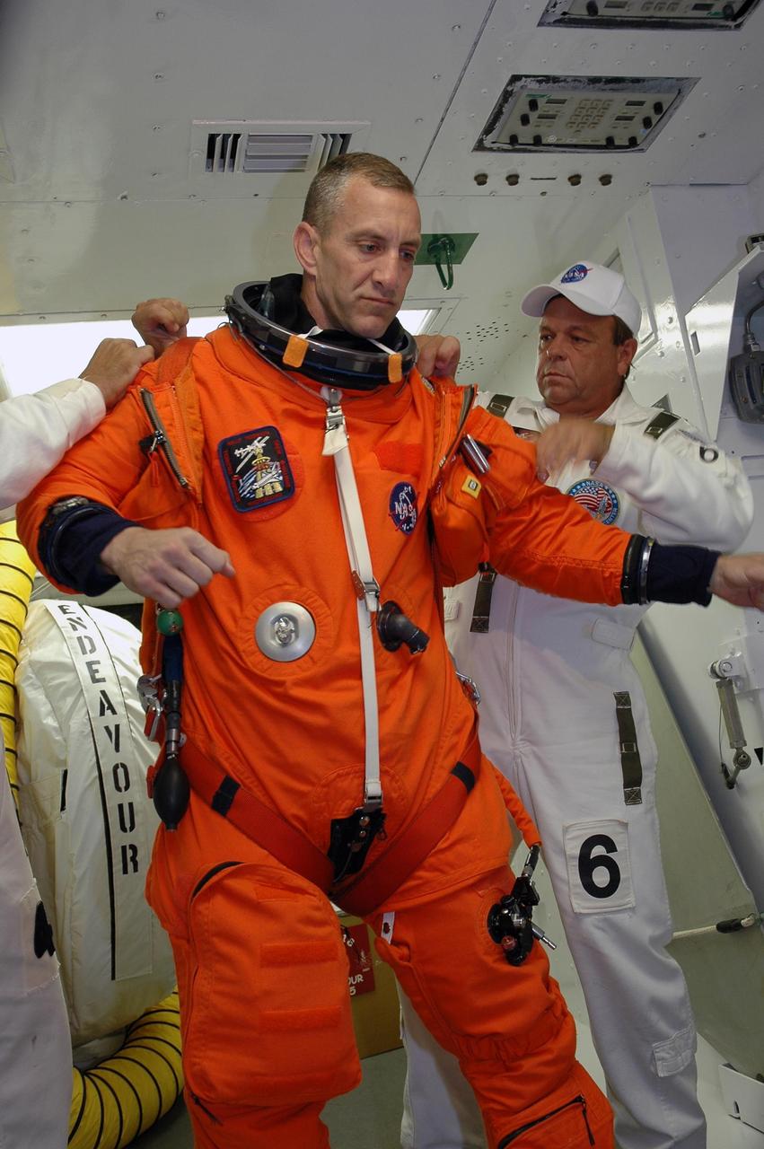 KENNEDY SPACE CENTER, Fla.  --  In the White Room on Launch Pad 39A, the closeout crew prepares the launch and entry suit on STS-118 Pilot Charlie Hobaugh before he enters Space Shuttle Endeavour.  Hobaugh and the rest of the crew are taking part in a simulated launch countdown, the culmination of terminal countdown demonstration test activities.  The White Room is situated at the end of the orbiter access arm and provides entry into the orbiter. TCDT activities also include M-113 training, payload familiarization and emergency egress training at the pad.  The mission is the 22nd flight to the International Space Station and Space Shuttle Endeavour will carry a payload including the S5 truss, a SPACEHAB module and external stowage platform 3. STS-118 is targeted for launch on Aug. 7.  Photo credit: NASA/Amanda Diller