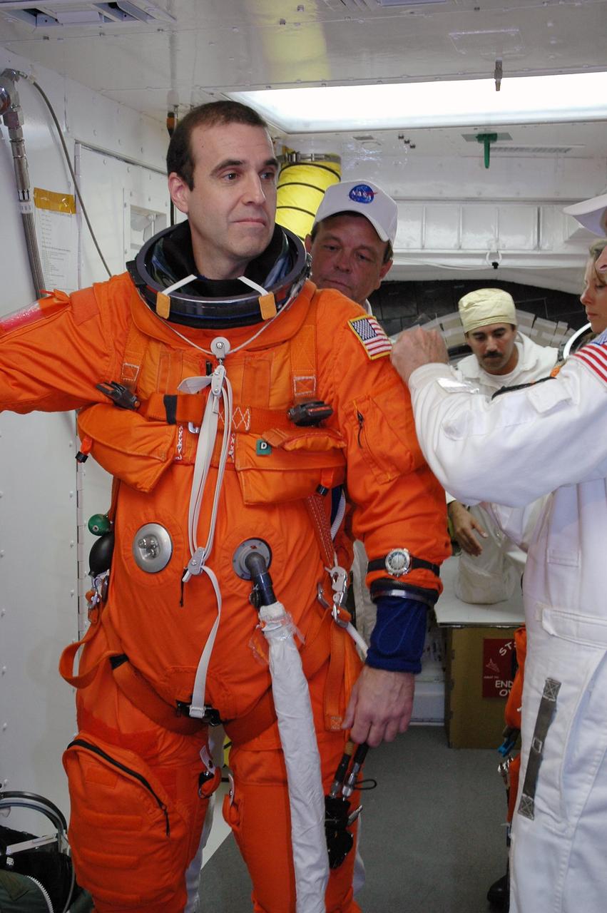 KENNEDY SPACE CENTER, Fla. -- In the White Room on Launch Pad 39A, the closeout crew prepares the launch and entry suit on STS-118 Mission Specialist Rick Mastracchio before he enters Space Shuttle Endeavour. Mastracchio and the rest of the crew are taking part in a simulated launch countdown, the culmination of terminal countdown demonstration test activities. The White Room is situated at the end of the orbiter access arm and provides entry into the orbiter. TCDT activities also include M-113 training, payload familiarization and emergency egress training at the pad. The mission is the 22nd flight to the International Space Station and Space Shuttle Endeavour will carry a payload including the S5 truss, a SPACEHAB module and external stowage platform 3. STS-118 is targeted for launch on Aug. 7. Photo credit: NASA/Amanda Diller