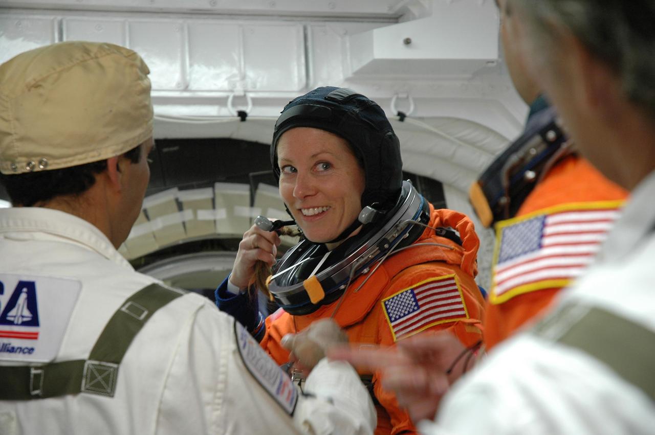 KENNEDY SPACE CENTER, Fla. -- In the White Room on Launch Pad 39A, the closeout crew prepares the launch and entry suit on STS-118 Mission Specialist Tracy Caldwell before she enters Space Shuttle Endeavour. Caldwell and the rest of the crew are taking part in a simulated launch countdown, the culmination of terminal countdown demonstration test activities. The White Room is situated at the end of the orbiter access arm and provides entry into the orbiter. TCDT activities also include M-113 training, payload familiarization and emergency egress training at the pad. The mission is the 22nd flight to the International Space Station and Space Shuttle Endeavour will carry a payload including the S5 truss, a SPACEHAB module and external stowage platform 3. STS-118 is targeted for launch on Aug. 7. Photo credit: NASA/Amanda Diller
