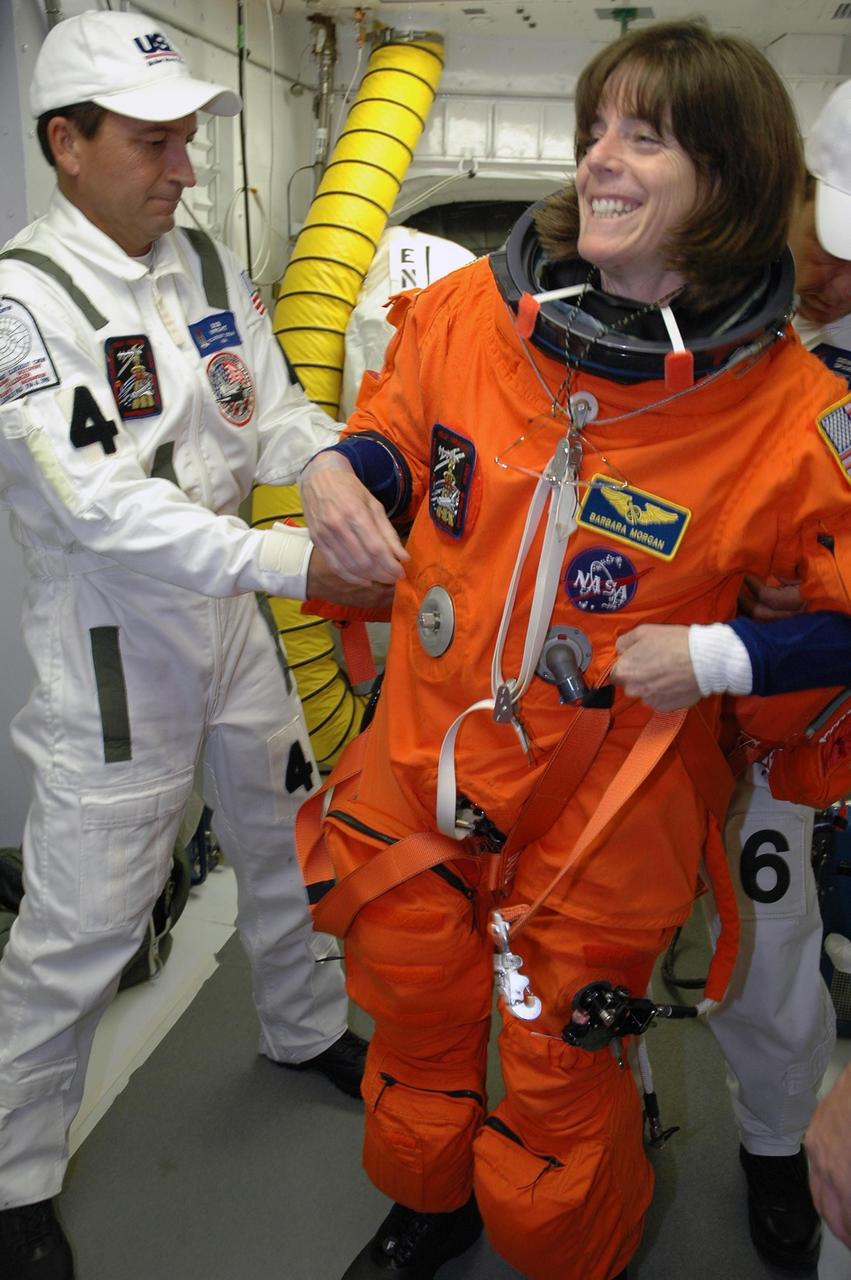 KENNEDY SPACE CENTER, Fla.  --  In the White Room on Launch Pad 39A, the closeout crew prepares the launch and entry suit on STS-118 Mission Specialist Barbara R. Morgan before she enters Space Shuttle Endeavour.  Morgan, the teacher-turned-astronaut, and the rest of the crew are taking part in a simulated launch countdown, the culmination of terminal countdown demonstration test activities.  The White Room is situated at the end of the orbiter access arm and provides entry into the orbiter. TCDT activities also include M-113 training, payload familiarization and emergency egress training at the pad.  The mission is the 22nd flight to the International Space Station and Space Shuttle Endeavour will carry a payload including the S5 truss, a SPACEHAB module and external stowage platform 3. STS-118 is targeted for launch on Aug. 7.  Photo credit: NASA/Amanda Diller