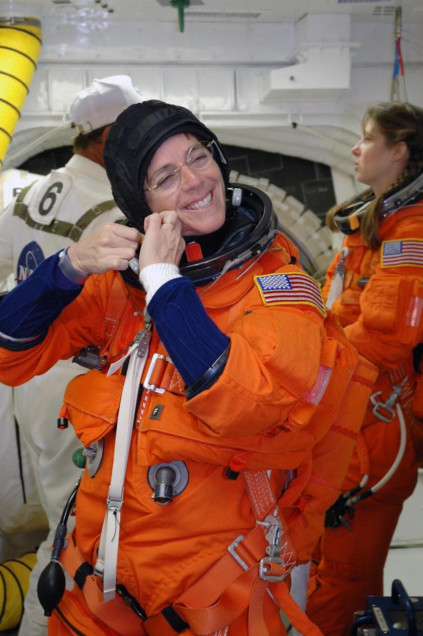 KENNEDY SPACE CENTER, Fla.  -- In the White Room on Launch Pad 39A, Mission Specialist Barbara R. Morgan adjusts the collar of her launch and entry suit before she enters Space Shuttle Endeavour.  Morgan, the teacher-turned-astronaut, and the rest of the crew are taking part in a simulated launch countdown, the culmination of terminal countdown demonstration test activities.  The White Room is situated at the end of the orbiter access arm and provides entry into the orbiter. TCDT activities also include M-113 training, payload familiarization and emergency egress training at the pad.  The mission is the 22nd flight to the International Space Station and Space Shuttle Endeavour will carry a payload including the S5 truss, a SPACEHAB module and external stowage platform 3. STS-118 is targeted for launch on Aug. 7.  Photo credit: NASA/Amanda Diller