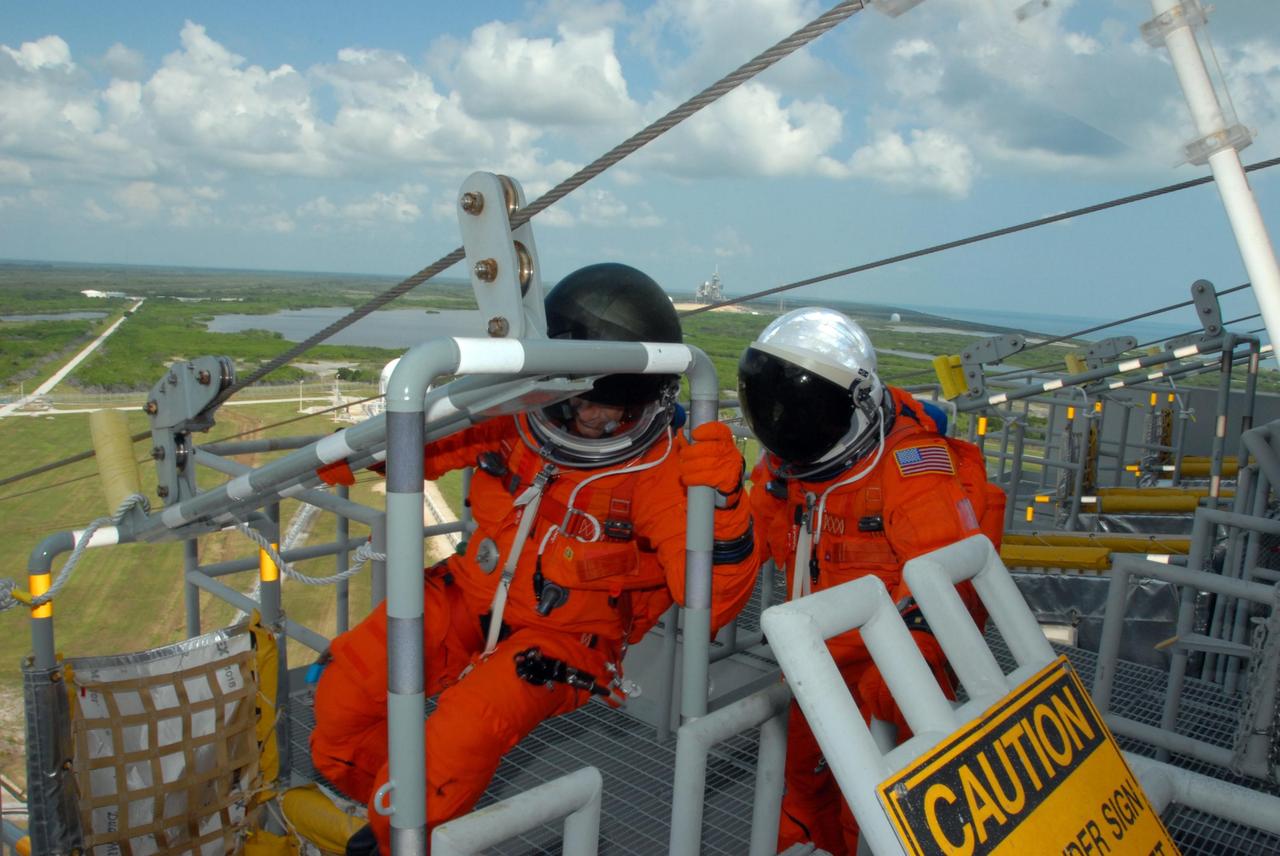 KENNEDY SPACE CENTER, Fla.  --  Practicing emergency egress from Launch Pad 39A, STS-118 crew members climb into a slidewire basket.  They are taking part in terminal countdown demonstration test activities that included a simulated launch countdown.  The crew comprises Commander Scott Kelly, Pilot Charlie Hobaugh and Mission Specialists Dave Williams, Barbara R. Morgan, Rick Mastracchio, Tracy Caldwell and Alvin Drew.  Williams represents the Canadian Space Agency.  Morgan joined NASA's Teacher in Space program in 1985 and was selected as an astronaut in 1998.  The STS-118 mission on Space Shuttle Endeavour is the 22nd flight to the International Space Station and will carry a payload including the S5 truss, a SPACEHAB module and external stowage platform 3. STS-118 is targeted for launch on Aug. 7.  Photo credit: NASA/George Shelton