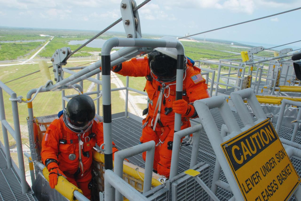KENNEDY SPACE CENTER, Fla.  --  Practicing emergency egress from Launch Pad 39A, STS-118 crew members climb into a slidewire basket.  They are taking part in terminal countdown demonstration test activities that included a simulated launch countdown. The crew comprises Commander Scott Kelly, Pilot Charlie Hobaugh and Mission Specialists Dave Williams, Barbara R. Morgan, Rick Mastracchio, Tracy Caldwell and Alvin Drew.  Williams represents the Canadian Space Agency.  Morgan joined NASA's Teacher in Space program in 1985 and was selected as an astronaut in 1998.  The STS-118 mission on Space Shuttle Endeavour is the 22nd flight to the International Space Station and will carry a payload including the S5 truss, a SPACEHAB module and external stowage platform 3. STS-118 is targeted for launch on Aug. 7.  Photo credit: NASA/George Shelton