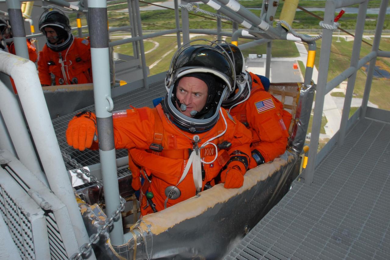 KENNEDY SPACE CENTER, Fla.  --  Practicing emergency egress from Launch Pad 39A, STS-118 Commander Scott Kelly (left) reaches for the pull lever of the slidewire basket.  Behind him is Pilot Charlie Hobaugh.  At upper left in another basket is Mission Specialist Rick Mastracchio.  Other crew members are Mission Specialists Dave Williams, Barbara R. Morgan, Tracy Caldwell and Alvin Drew.  Morgan joined NASA's Teacher in Space program in 1985 and was selected as an astronaut in 1998.  Williams represents the Canadian Space Agency.  The STS-118 mission on Space Shuttle Endeavour is the 22nd flight to the International Space Station and will carry a payload including the S5 truss, a SPACEHAB module and external stowage platform 3. STS-118 is targeted for launch on Aug. 7.  NASA/George Shelton