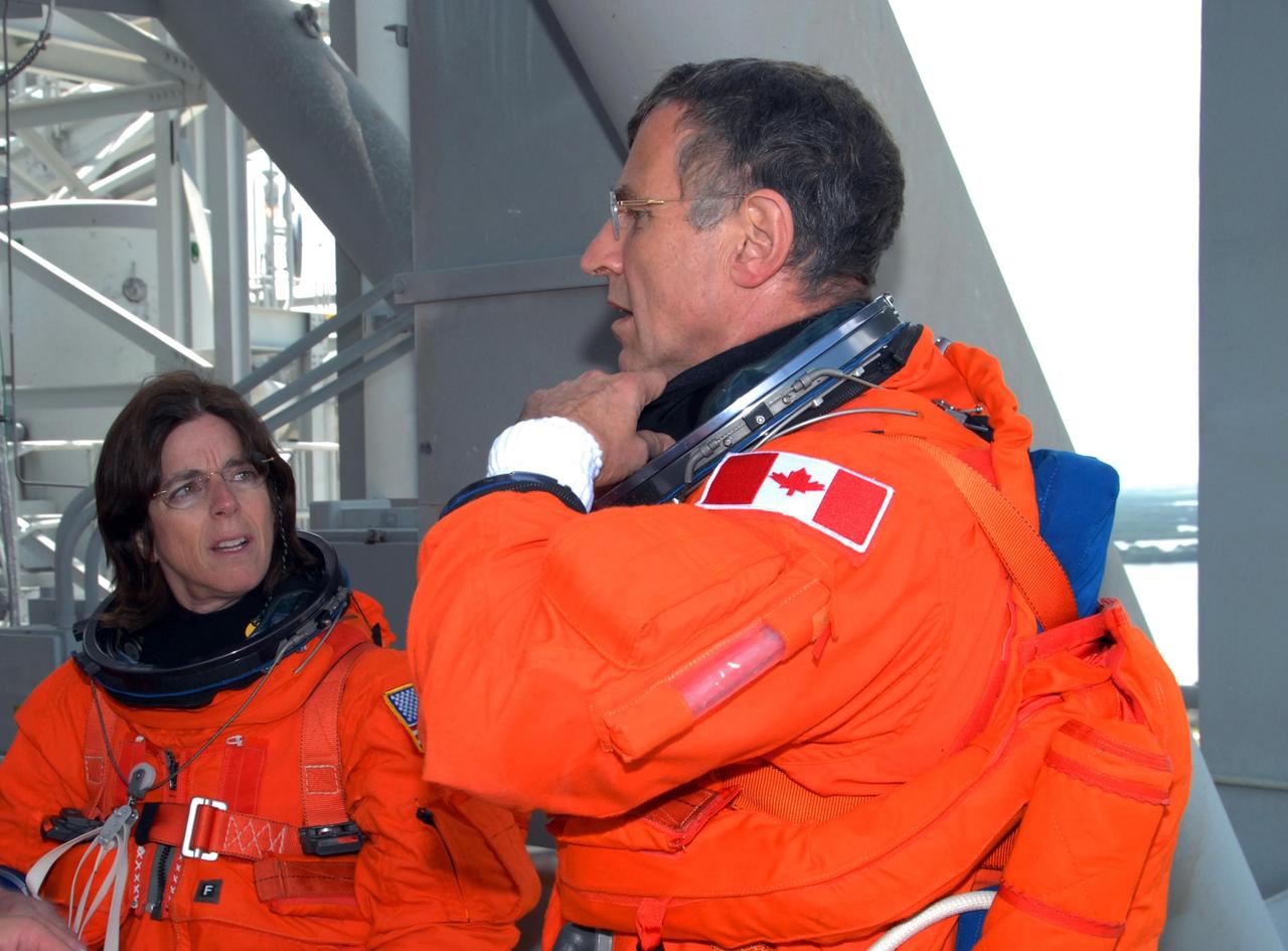 KENNEDY SPACE CENTER, Fla.  --  After practicing emergency egress from Launch Pad 39A, STS-118 Mission Specialists Barbara R. Morgan and Dave Williams relax their launch and entry suits.  Morgan joined NASA's Teacher in Space program in 1985 and was selected as an astronaut in 1998.  Williams represents the Canadian Space Agency.  The crew is concluding the terminal countdown demonstration test. The STS-118 mission on Space Shuttle Endeavour is the 22nd flight to the International Space Station and will carry a payload including the S5 truss, a SPACEHAB module and external stowage platform 3. STS-118 is targeted for launch on Aug. 7. Photo credit: NASA/George Shelton