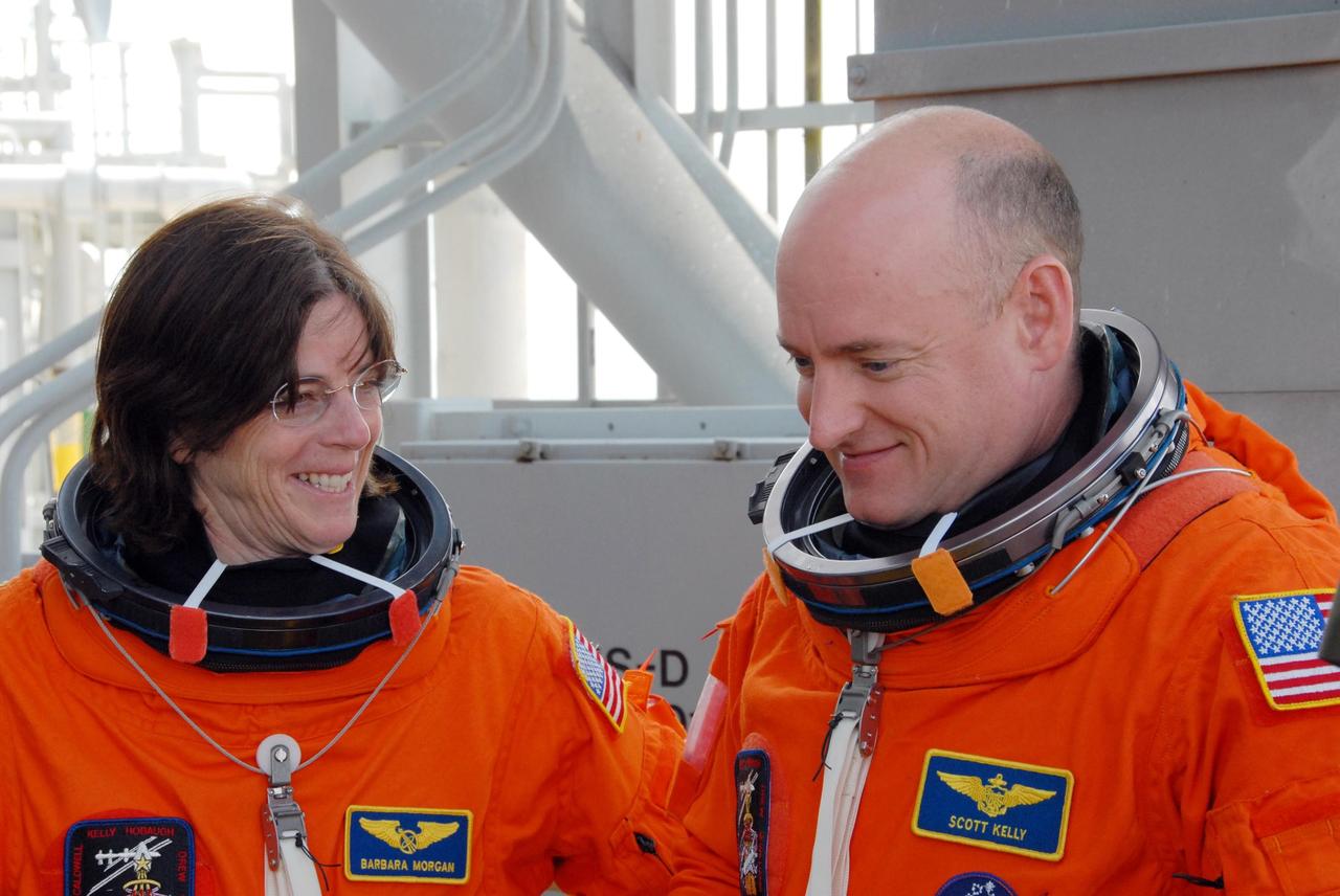 KENNEDY SPACE CENTER, Fla.  --  After practicing emergency egress from Launch Pad 39A, STS-118 Mission Specialist Barbara R. Morgan and Commander Scott Kelly relax for a moment.  Morgan, who is making her first space flight, joined NASA's Teacher in Space program in 1985 and was selected as an astronaut in 1998.  The crew is concluding the terminal countdown demonstration test.  The STS-118 mission on Space Shuttle Endeavour is the 22nd flight to the International Space Station and will carry a payload including the S5 truss, a SPACEHAB module and external stowage platform 3. STS-118 is targeted for launch on Aug. 7.  Photo credit: NASA/George Shelton