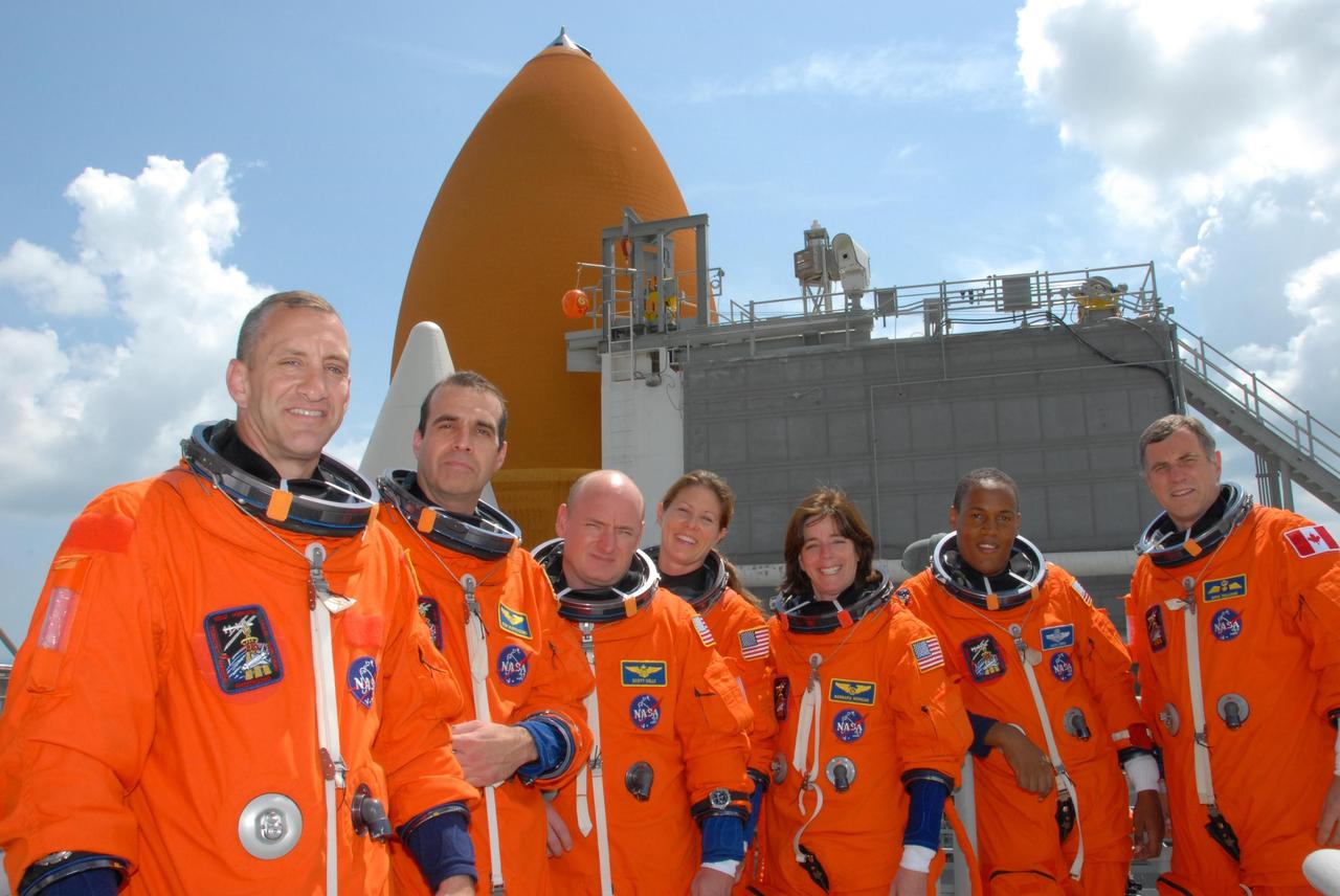 KENNEDY SPACE CENTER, Fla.  --   On top of the fixed service structure of Launch Pad 39A, The STS-118 crew poses for a photo after conclusion of the terminal countdown demonstration test.  From left are Pilot Charlie Hobaugh, Mission Specialist Rick Mastracchio, Commander Scott Kelly, and Mission Specialists Tracy Caldwell, Barbara R. Morgan, Alvin Drew and Dave Williams.  Morgan, who is making her first space flight, joined NASA's Teacher in Space program in 1985 and was selected as an astronaut in 1998.  Williams represents the Canadian Space Agency. The STS-118 mission on Space Shuttle Endeavour is the 22nd flight to the International Space Station and will carry a payload including the S5 truss, a SPACEHAB module and external stowage platform 3. STS-118 is targeted for launch on Aug. 7.  Photo credit:  NASA/George Shelton