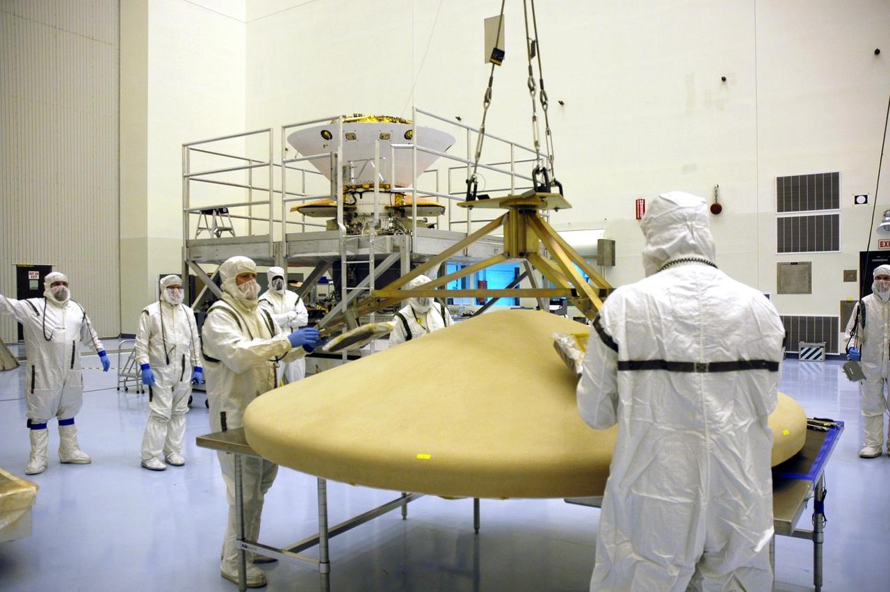 KENNEDY SPACE CENTER, Fla. -- In the Payload Hazardous Servicing Facility, workers attach a crane to the heat shield for the Phoenix Mars Lander spacecraft. The crane will lift and move the heat shield for installation over the lander within the cruise stage. Targeted for launch from Cape Canaveral Air Force Station on Aug. 3, Phoenix will land in icy soils near the north polar permanent ice cap of Mars and explore the history of the water in these soils and any associated rocks, while monitoring polar climate. Landing on Mars is planned in May 2008 on arctic ground where a mission currently in orbit, Mars Odyssey, has detected high concentrations of ice just beneath the top layer of soil. Photo credit: NASA/Troy Cryder