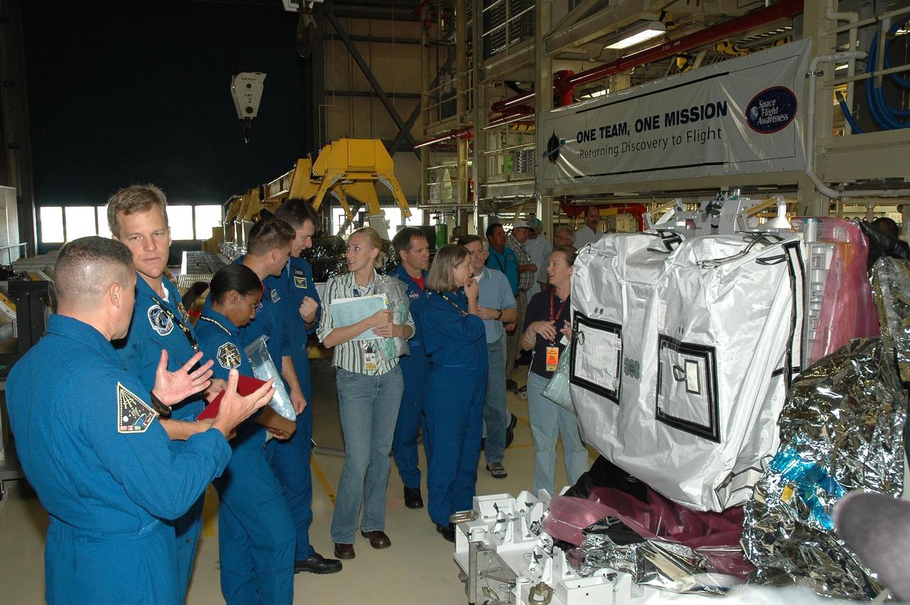 KENNEDY SPACE CENTER, Fla.  --  In the Orbiter Processing Facility bay 3, STS-120 crew members get a look at the main bus switching unit that is part of the payload on their mission.  From left are Pilot George Zamka, Mission Specialists Scott Parazynski and Stephanie Wilson,  astronaut Dan Tani, who will join the International Space Station crew, and Mission Specialists Paolo Nespoli, Doug Wheelock and Commander Pam Melroy.  Nespoli represents the European Space Agency.  A main bus switching unit is used for power distribution, circuit protection and fault isolation on the space station's power system.  The units route power to proper locations in the space station, such as from solar arrays through umbilicals into the U.S. Lab.  The unit will be installed on the external stowage platform 2 attached to the Quest airlock for temporary storage.  Discovery is targeted to launch mission STS-120 no earlier than Oct. 20.  Photo credit: NASA/Jim Grossmann