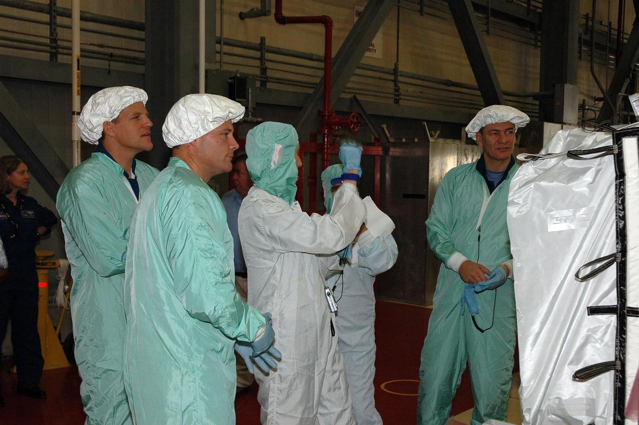 KENNEDY SPACE CENTER, Fla.  --  In the Orbiter Processing Facility bay 3, STS-120 crew members get a look at the main bus switching unit that is part of the payload on their mission.  From left are Mission Specialists Scott Parazynski and Doug Wheelock at left and Mission Specialist Paolo Nespoli at right.  Nespoli represents the European Space Agency. A main bus switching unit is used for power distribution, circuit protection and fault isolation on the space station's power system.  The units route power to proper locations in the space station, such as from solar arrays through umbilicals into the U.S. Lab.  The unit will be installed on the external stowage platform 2 attached to the Quest airlock for temporary storage.  Discovery is targeted to launch mission STS-120 no earlier than Oct. 20.  Photo credit: NASA/Jim Grossmann