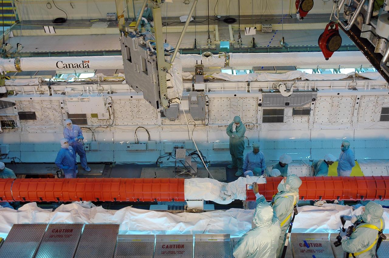 KENNEDY SPACE CENTER, Fla.  --  In the Orbiter Processing Facility bay 3, a crane lowers the main bus switching unit into Discovery's payload bay.  The unit is part of the payload on mission STS-120.A main bus switching unit is used for power distribution, circuit protection and fault isolation on the space station's power system.  The units route power to proper locations in the space station, such as from solar arrays through umbilicals into the U.S. Lab.  The unit will be installed on the external stowage platform 2 attached to the Quest airlock for temporary storage.  Discovery is targeted to launch mission STS-120 no earlier than Oct. 20.  Photo credit: NASA/Jim Grossmann
