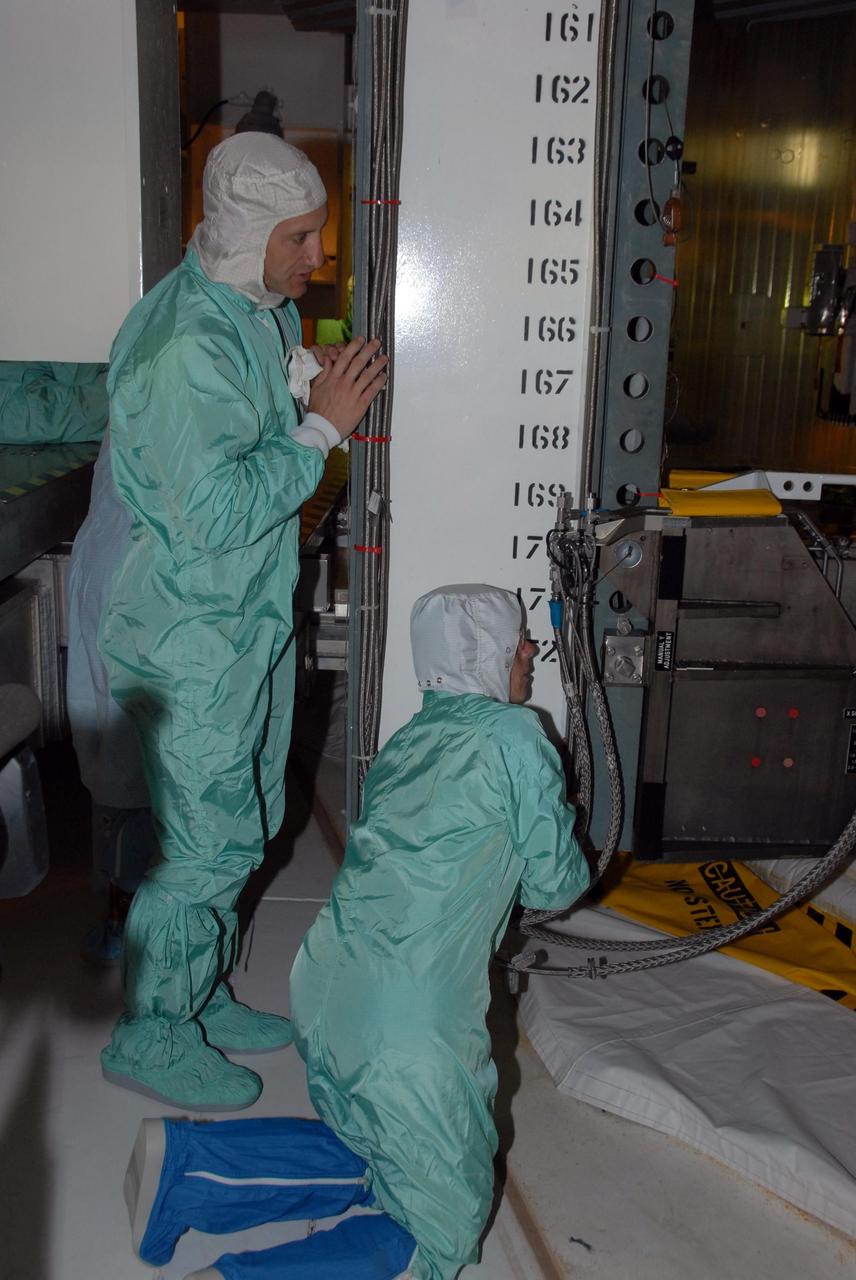 KENNEDY SPACE CENTER, Fla.  --  STS-118 crew members get a close look at the payloads installed in Space Shuttle Endeavour.  Seen here are Pilot Charlie Hobaugh (left) and Mission Specialist Barbara R. Morgan, who joined NASA's Teacher in Space program in 1985 and was selected as an astronaut in 1998.  The STS-118 crew has been at Kennedy for terminal countdown demonstration test activities that also include M-113 training, emergency egress training at the pad and a simulated launch countdown.  The mission is the 22nd flight to the International Space Station and Space Shuttle Endeavour will carry a payload including the S5 truss, a SPACEHAB module and external stowage platform 3. STS-118 is targeted for launch on Aug. 7.    Photo credit: NASA/George Shelton
