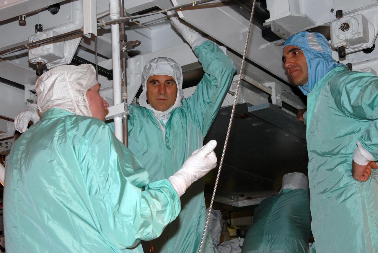 KENNEDY SPACE CENTER, Fla. -- STS-118 crew members confer with a technician about the payloads installed in Space Shuttle Endeavour. Seen here are Mission Specialists Dave Williams (center), who represents the Canadian Space Agency, and Rick Mastracchio (right). The STS-118 crew has been at Kennedy for terminal countdown demonstration test activities that also include M-113 training, emergency egress training at the pad and a simulated launch countdown. The mission is the 22nd flight to the International Space Station and Space Shuttle Endeavour will carry a payload including the S5 truss, a SPACEHAB module and external stowage platform 3. STS-118 is targeted for launch on Aug. 7. Photo credit: NASA/George Shelton
