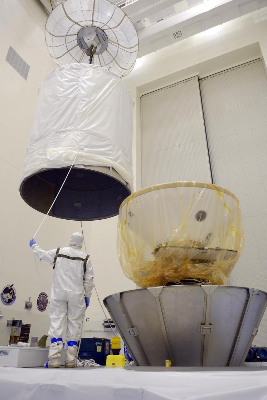 KENNEDY SPACE CENTER, Fla.  --  In the Payload Hazardous Servicing Facility, workers guide the upper part of the shipping canister toward the Phoenix Mars Lander.  It will be lowered over the top and attached to the lower sections.  After the canning, the Phoenix will be transferred to Launch Pad 17-A on Cape Canaveral Air Force Station in Florida for launch on Aug. 3.  Phoenix will land in icy soils near the north polar permanent ice cap of Mars and explore the history of the water in these soils and any associated rocks, while monitoring polar climate. Landing on Mars is planned in May 2008 on arctic ground where a mission currently in orbit, Mars Odyssey, has detected high concentrations of ice just beneath the top layer of soil. Photo credit: NASA/Kim Shiflett