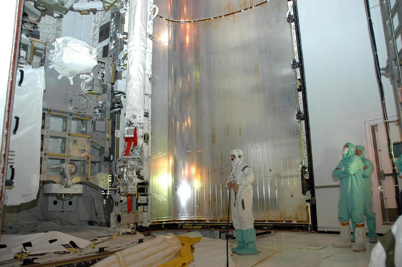 KENNEDY SPACE CENTER, FLA. — From inside the payload changeout room at Launch Pad 39A, workers check the progress of the closing of Endeavour's payload bay doors. The payload includes the S5 truss, the SPACEHAB module and external stowage platform 3. The mission is the 22nd flight to the International Space Station and is targeted for launch on Aug. 7. NASA/Charisse Nahser
