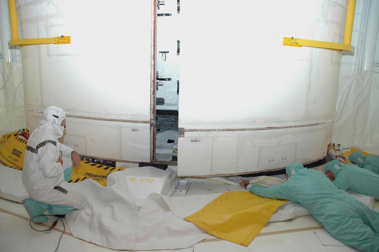 KENNEDY SPACE CENTER, FLA. — From inside the payload changeout room at Launch Pad 39A, workers check the closing of Endeavour's payload bay doors. The payload includes the S5 truss, the SPACEHAB module and external stowage platform 3. The mission is the 22nd flight to the International Space Station and is targeted for launch on Aug. 7. NASA/Charisse Nahser