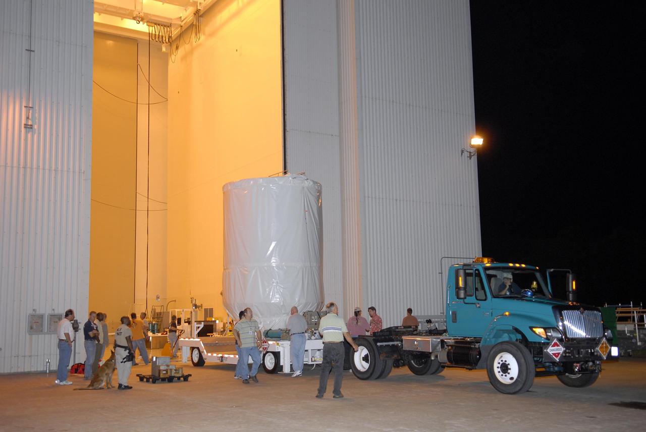 KENNEDY SPACE CENTER, FLA. — The Phoenix Mars Lander, on its transporter, is escorted out of the Payload Hazardous Servicing Facility for its transfer to Launch Pad 17-A at Cape Canaveral Air Force Station. Launch of NASA's Phoenix Mars Lander is scheduled for Aug. 3. There are two instantaneous launch times, 5:35:18 and 6:11:24 a.m. EDT. Phoenix will land in icy soils near the north polar permanent ice cap of Mars and explore the history of the water in these soils and any associated rocks, while monitoring polar climate. Landing on Mars is planned in May 2008 on arctic ground where a mission currently in orbit, Mars Odyssey, has detected high concentrations of ice just beneath the top layer of soil. NASA/George Shelton