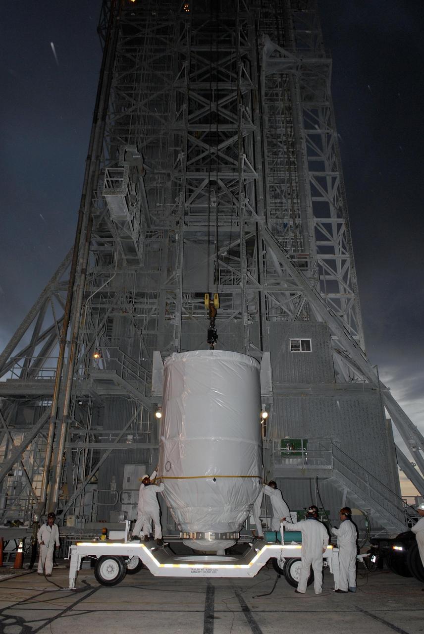 KENNEDY SPACE CENTER, FLA. — In front of the mobile service tower on Launch Pad 17-A at Cape Canaveral Air Force Station, workers attach an overhead crane to the Phoenix Mars Lander. The lander will be lifted up into the tower for mating to the Delta II launch vehicle. Launch of NASA's Phoenix Mars Lander is scheduled for Aug. 3. There are two instantaneous launch times, 5:35:18 and 6:11:24 a.m. EDT. Phoenix will land in icy soils near the north polar permanent ice cap of Mars and explore the history of the water in these soils and any associated rocks, while monitoring polar climate. Landing on Mars is planned in May 2008 on arctic ground where a mission currently in orbit, Mars Odyssey, has detected high concentrations of ice just beneath the top layer of soil. NASA/George Shelton