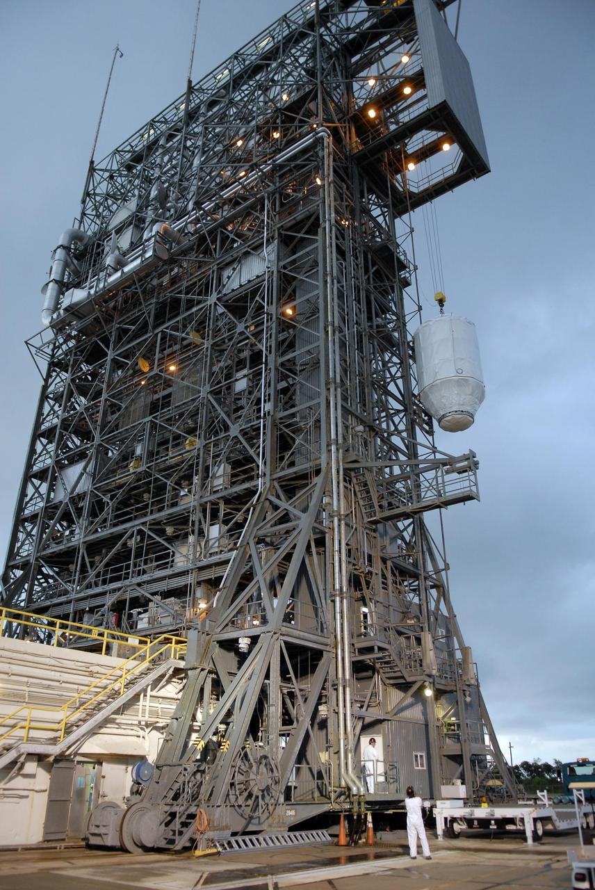 KENNEDY SPACE CENTER, FLA. — Attached to an overhead crane, the Phoenix Mars Lander is lifted up alongside the mobile service tower on Launch Pad 17-A at Cape Canaveral Air Force Station. Once inside the tower, the lander will be mated to the Delta II launch vehicle. Launch of NASA's Phoenix Mars Lander is scheduled for Aug. 3. There are two instantaneous launch times, 5:35:18 and 6:11:24 a.m. EDT. Phoenix will land in icy soils near the north polar permanent ice cap of Mars and explore the history of the water in these soils and any associated rocks, while monitoring polar climate. Landing on Mars is planned in May 2008 on arctic ground where a mission currently in orbit, Mars Odyssey, has detected high concentrations of ice just beneath the top layer of soil. NASA/George Shelton