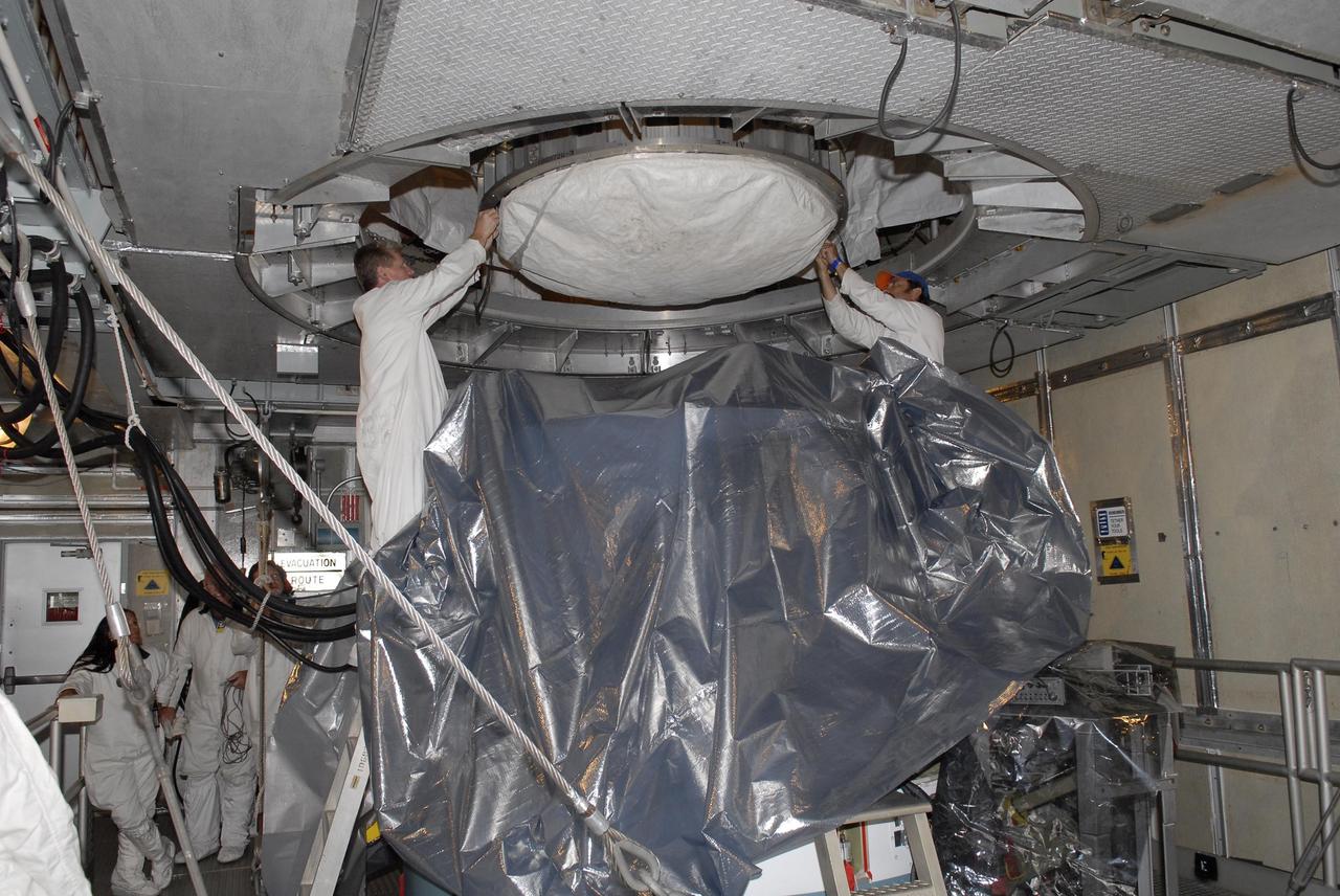KENNEDY SPACE CENTER, FLA. — Inside the mobile service tower on Launch Pad 17-A, the Phoenix Mars Lander is lowered toward the Delta II second stage for mating. Launch of NASA's Phoenix Mars Lander is scheduled for Aug. 3. There are two instantaneous launch times, 5:35:18 and 6:11:24 a.m. EDT. Phoenix will land in icy soils near the north polar permanent ice cap of Mars and explore the history of the water in these soils and any associated rocks, while monitoring polar climate. Landing on Mars is planned in May 2008 on arctic ground where a mission currently in orbit, Mars Odyssey, has detected high concentrations of ice just beneath the top layer of soil. NASA/George Shelton