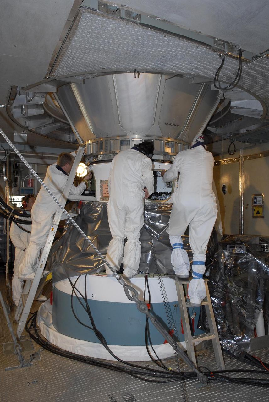 KENNEDY SPACE CENTER, FLA. — Inside the mobile service tower, the Phoenix Mars Lander is lowered toward the Delta II second stage for mating. Launch of NASA's Phoenix Mars Lander is scheduled for Aug. 3. There are two instantaneous launch times, 5:35:18 and 6:11:24 a.m. EDT. Phoenix will land in icy soils near the north polar permanent ice cap of Mars and explore the history of the water in these soils and any associated rocks, while monitoring polar climate. Landing on Mars is planned in May 2008 on arctic ground where a mission currently in orbit, Mars Odyssey, has detected high concentrations of ice just beneath the top layer of soil. NASA/George Shelton