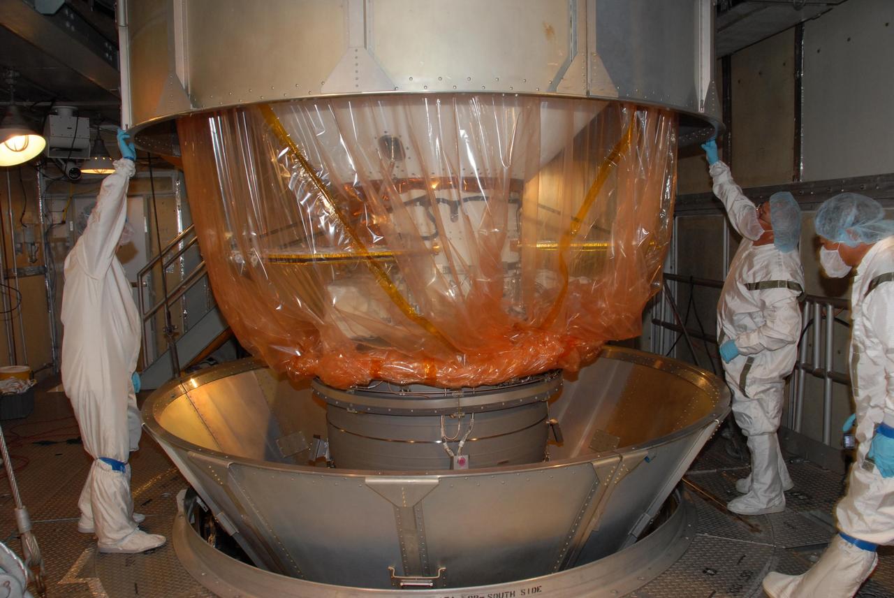 KENNEDY SPACE CENTER, FLA. -- Inside the mobile service tower of Launch Pad 17-A at Cape Canaveral Air Force Station in Florida, workers remove the container from NASA's Phoenix Mars Lander. Launch of Phoenix is scheduled to launch on the Delta II launch vehicle no earlier than Aug. 3. Phoenix will land in icy soils near the north polar permanent ice cap of Mars and explore the history of the water in these soils and any associated rocks, while monitoring polar climate. Landing on Mars is planned in May 2008 on arctic ground where a mission currently in orbit, Mars Odyssey, detected high concentrations of ice just beneath the top layer of soil. NASA/George Shelton