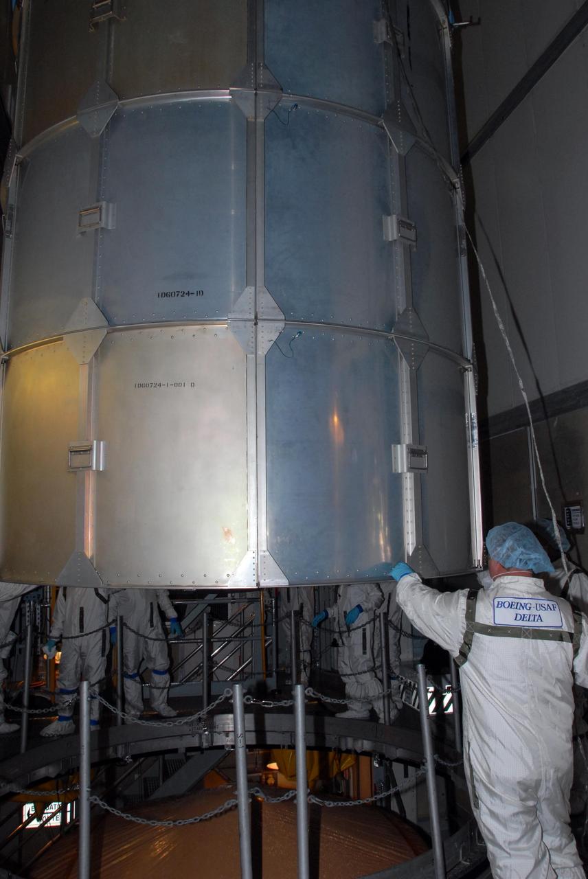 KENNEDY SPACE CENTER, FLA. -- Inside the mobile service tower of Launch Pad 17-A at Cape Canaveral Air Force Station in Florida, workers remove the container lid from NASA's Phoenix Mars Lander. Launch of Phoenix is scheduled to launch on the Delta II launch vehicle no earlier than Aug. 3. Phoenix will land in icy soils near the north polar permanent ice cap of Mars and explore the history of the water in these soils and any associated rocks, while monitoring polar climate. Landing on Mars is planned in May 2008 on arctic ground where a mission currently in orbit, Mars Odyssey, detected high concentrations of ice just beneath the top layer of soil. NASA/George Shelton