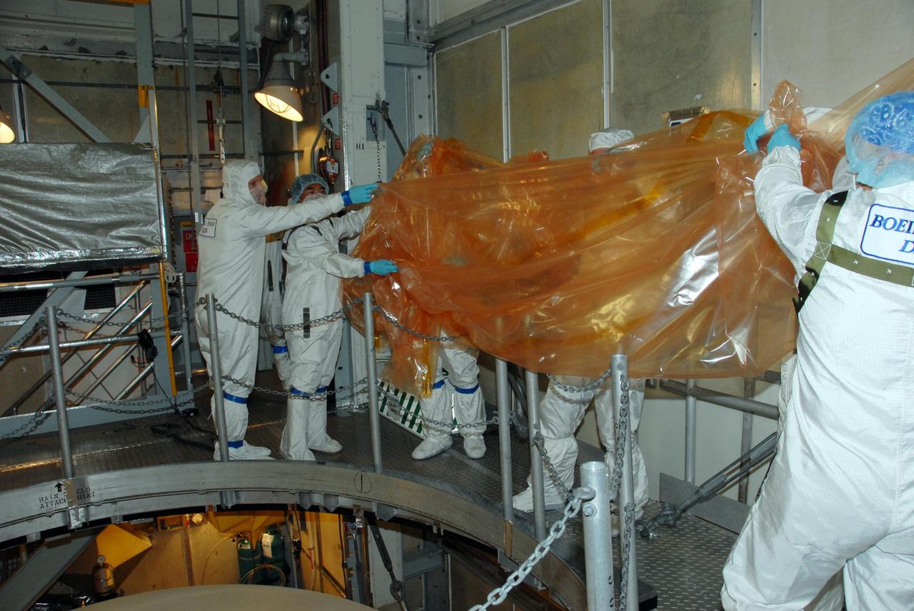KENNEDY SPACE CENTER, FLA. -- Inside the mobile service tower of Launch Pad 17-A at Cape Canaveral Air Force Station in Florida, workers removed the plastic covering from NASA's Phoenix Mars Lander. Phoenix is scheduled to launch on the Delta II launch vehicle no earlier than Aug. 3. Phoenix will land in icy soils near the north polar permanent ice cap of Mars and explore the history of the water in these soils and any associated rocks, while monitoring polar climate. Landing on Mars is planned in May 2008 on arctic ground where a mission currently in orbit, Mars Odyssey, detected high concentrations of ice just beneath the top layer of soil. NASA/George Shelton