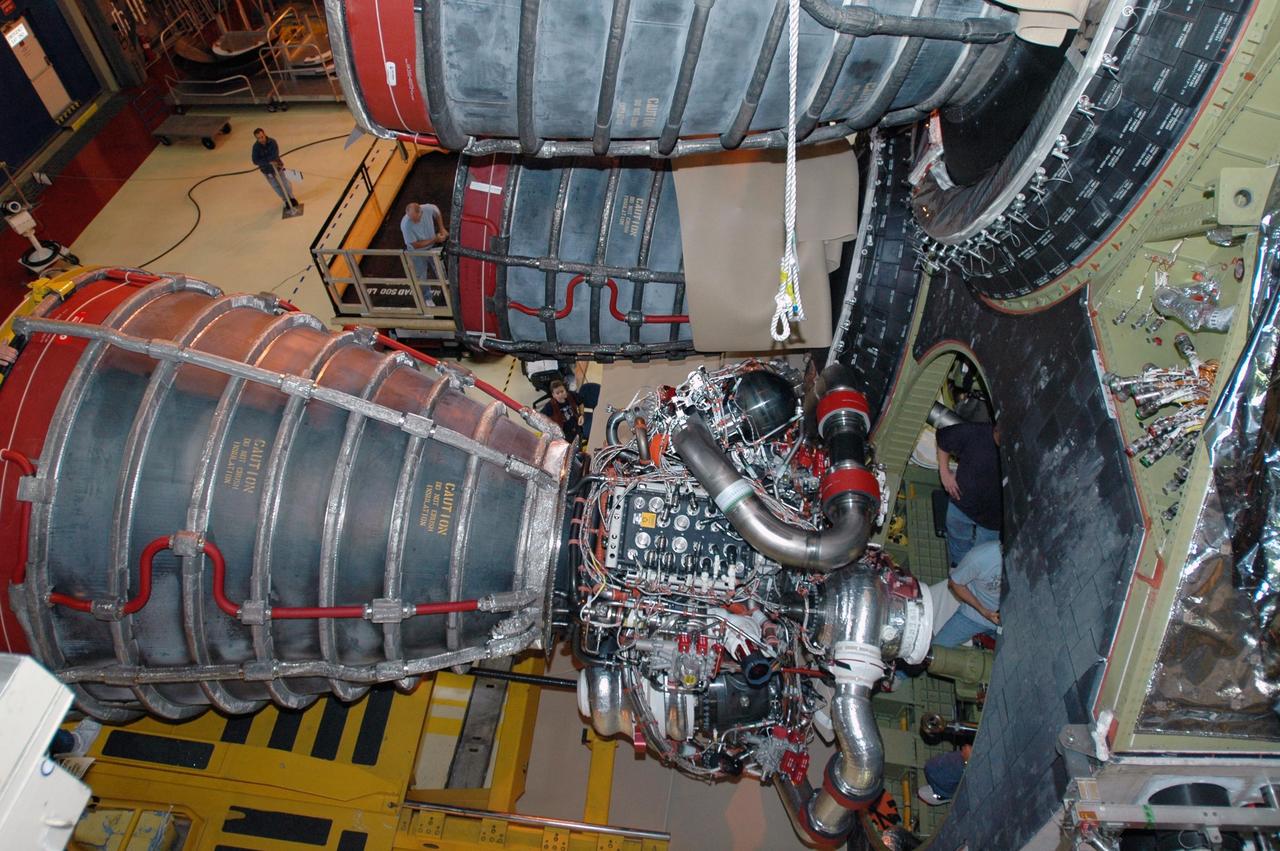 KENNEDY SPACE CENTER, FLA.  --   Inside Orbiter Processing Facility 3 at Kennedy Space Center, technicians prepare to install engine No. 3 as it nears the aft fuselage of the vehicle during processing for mission STS-120. Mission STS-120 will be the 23rd flight to the International Space Station. Space Shuttle Discovery will carry the U.S. Node 2. Launch is targeted for Oct. 20. NASA/Dimitri Gerondidakis